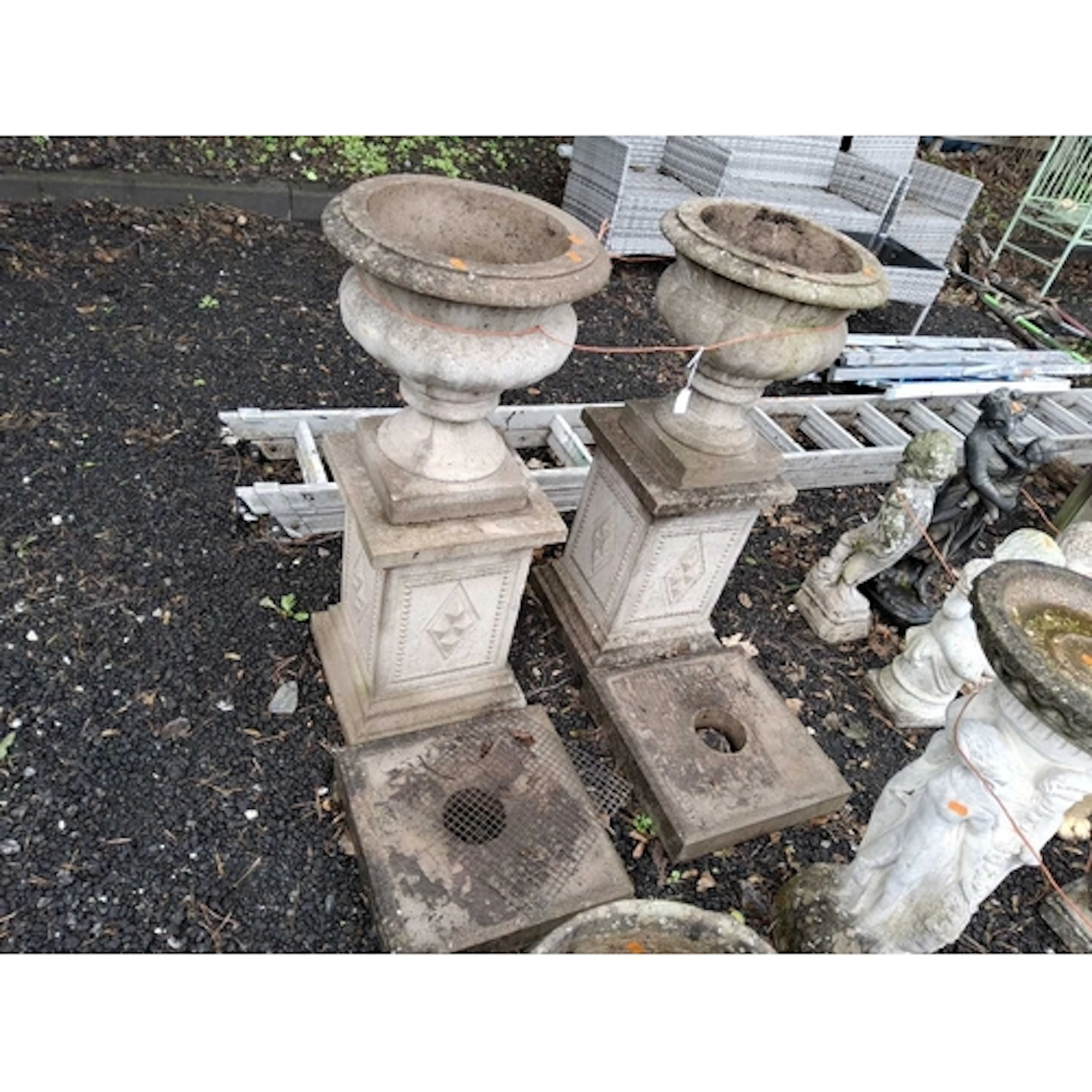 A PAIR OF CONCRETE GARDEN URNS with fluted balustered bowl a...