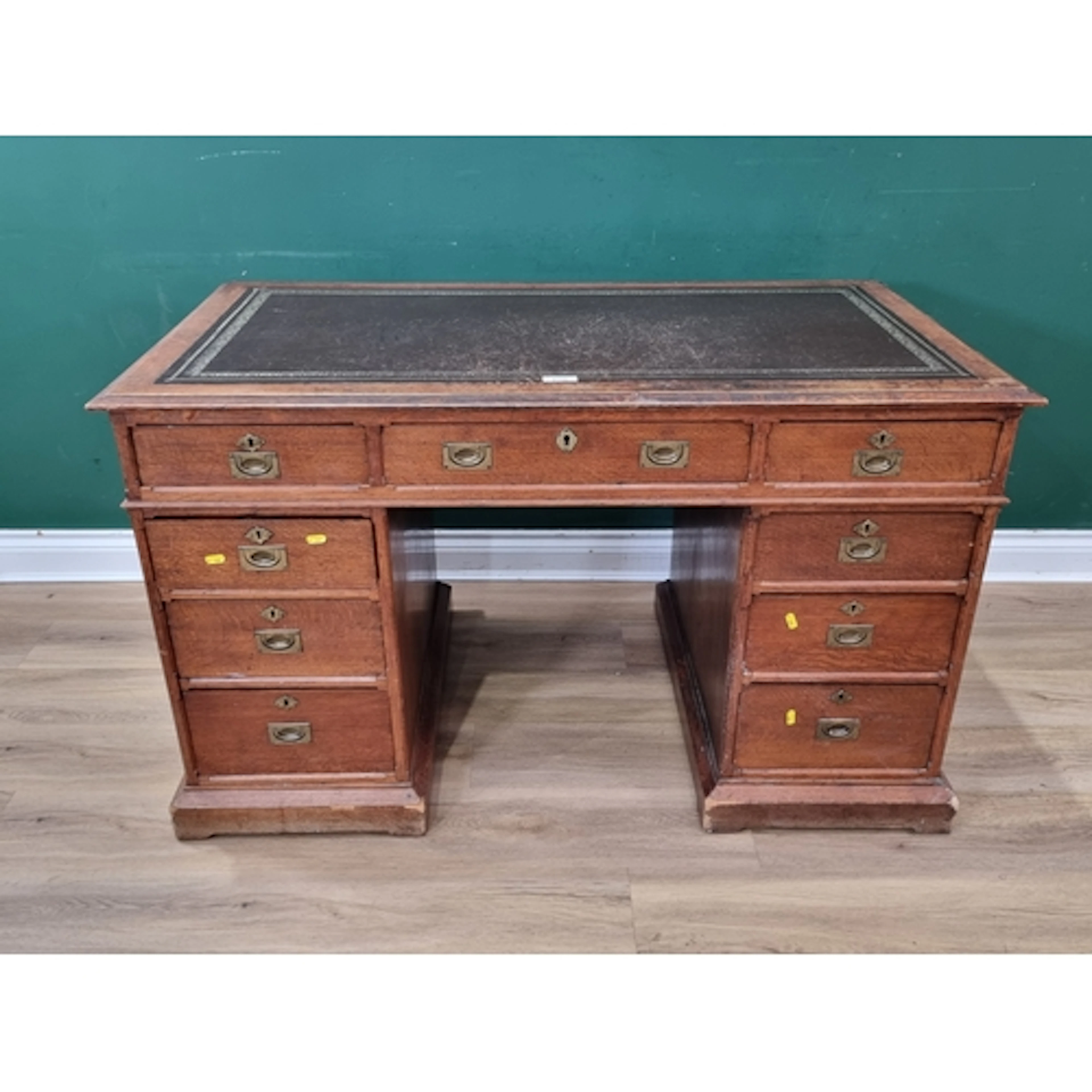 An oak Campaign style Desk with leather inset top fitted nin...