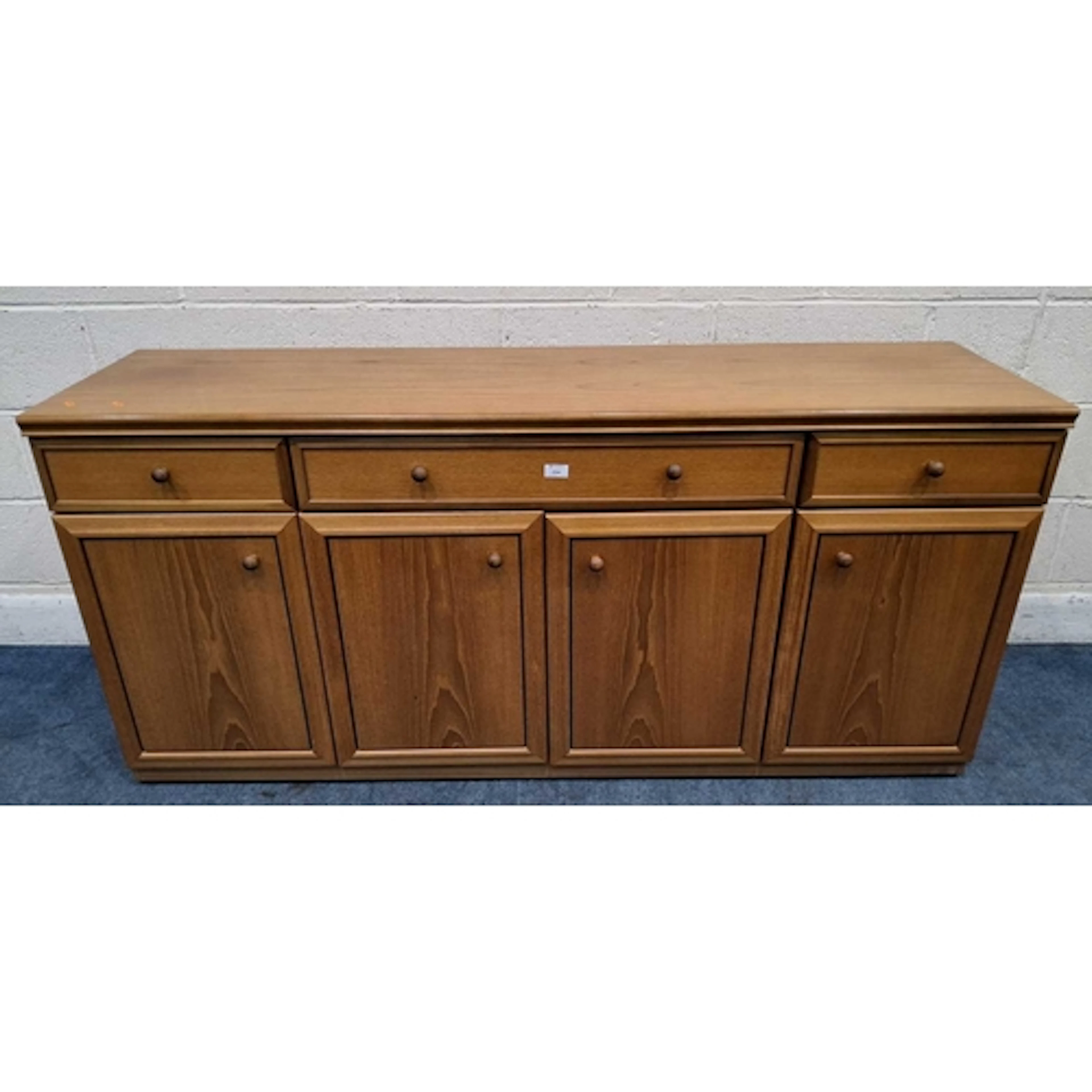 A MID-CENTURY TEAK SIDEBOARD, fitted with three drawers over...