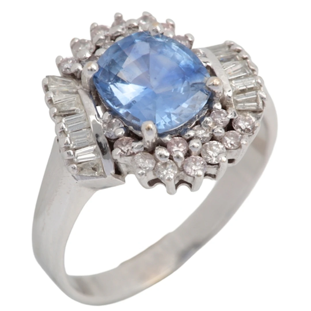 A sapphire and diamond ring, claw-set with a cushion-shaped ...