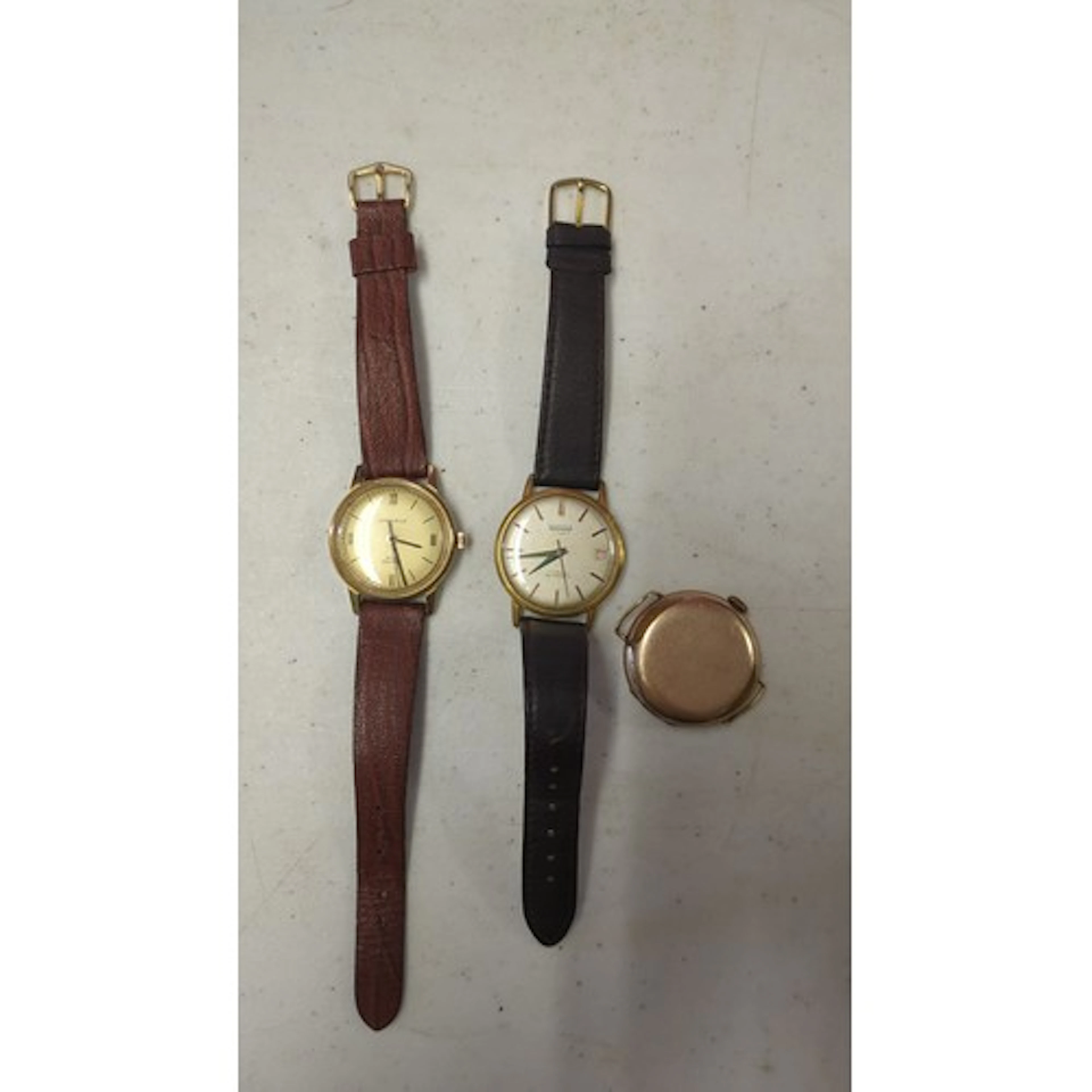 A group of three gold-tone wristwatches, including Caravelle...