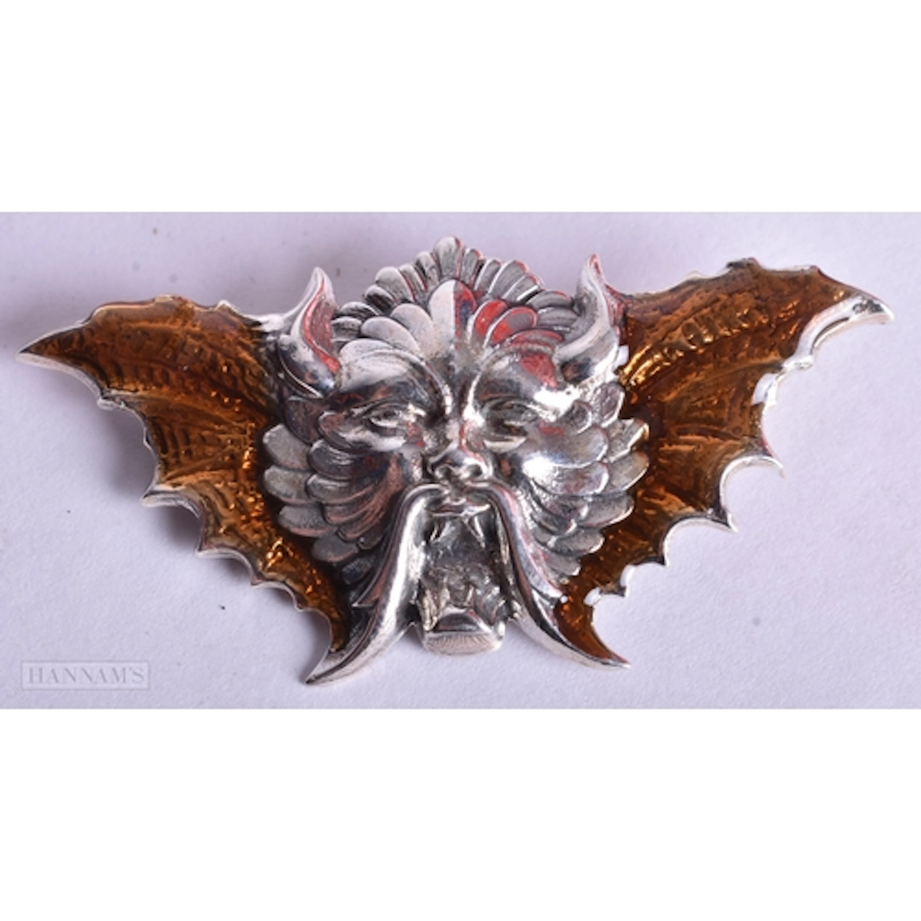 A SILVER ENAMEL MASK BROOCH. 8.5 grams. 5.5 cm x 2.5 cm.
