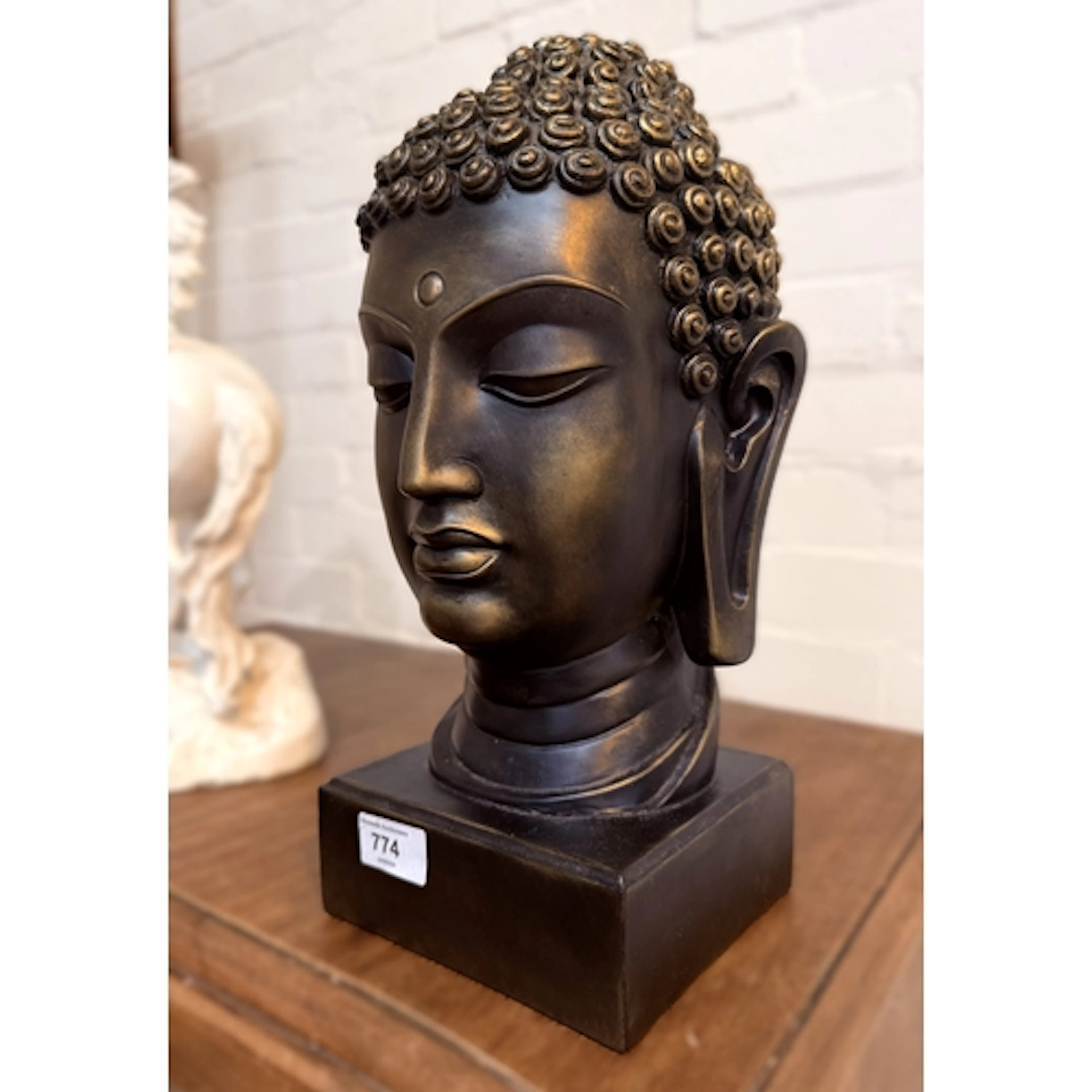 A modern resin bronze finish Buddha head sculpture.
