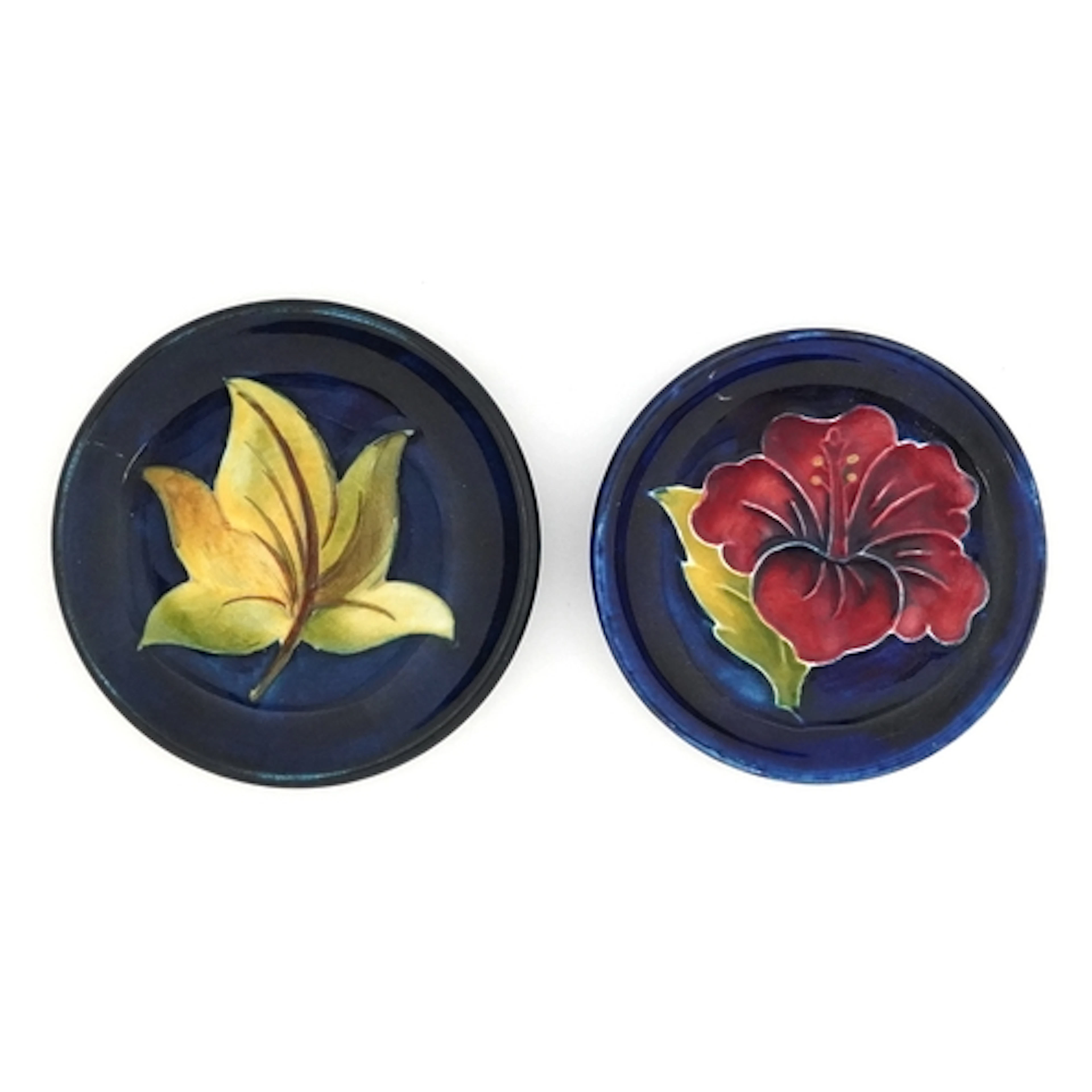 Two Moorcroft circular pin dishes hand painted with flowers,...