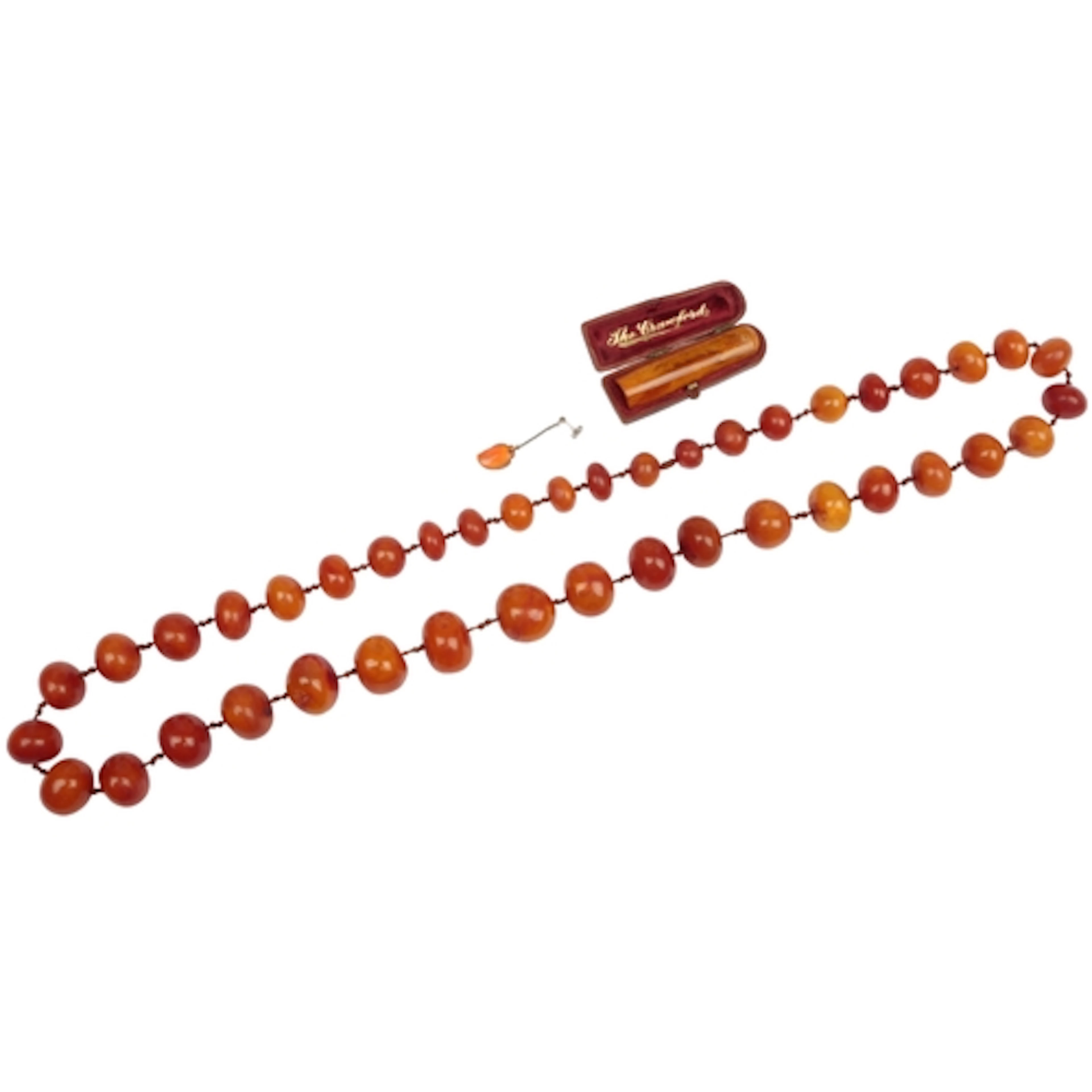 An amber bead necklace and cheroot holder, the necklace comp...