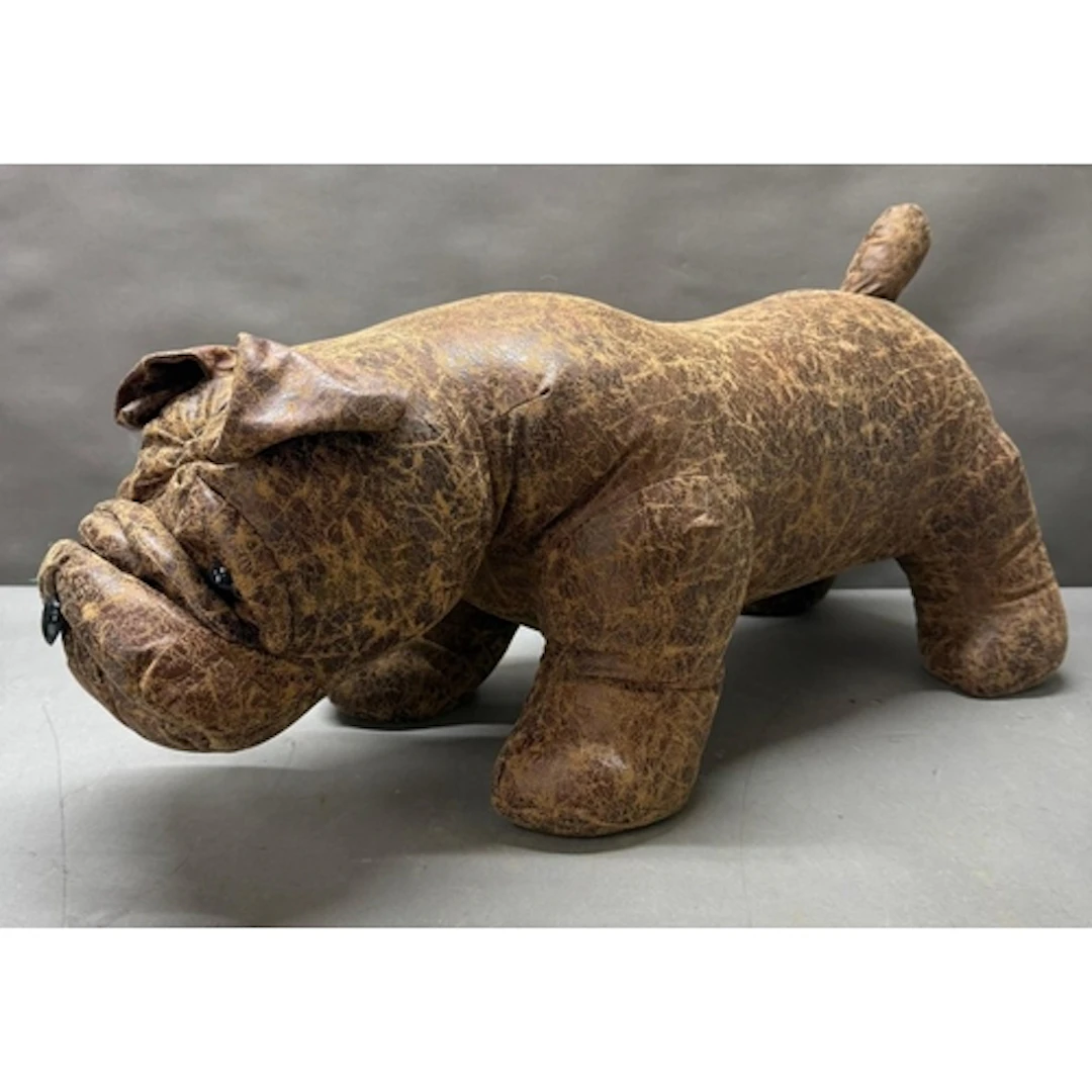 A brown leather footstool in the form of a bull dog