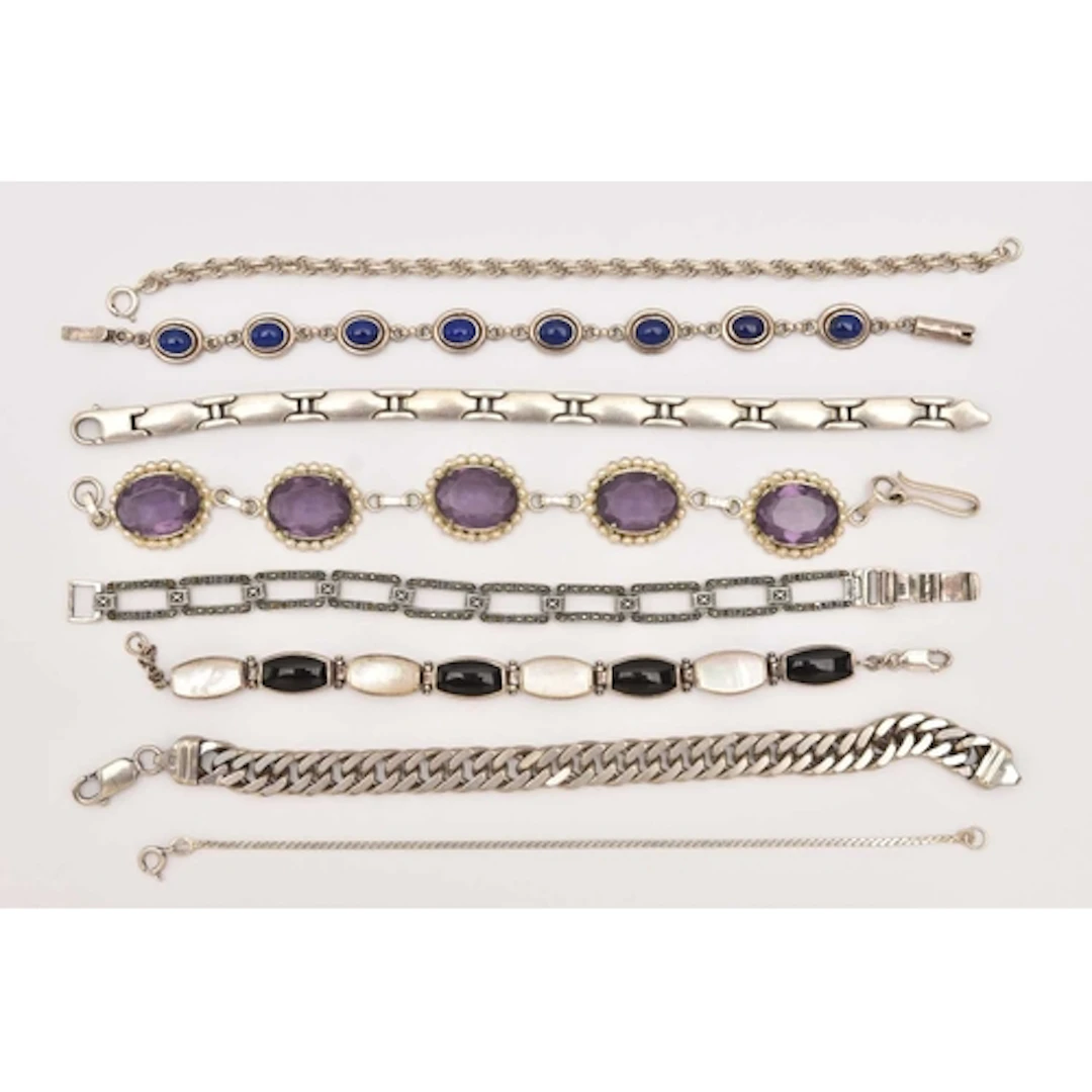AN ASSORTMENT OF SILVER AND WHITE METAL BRACELETS, to includ...