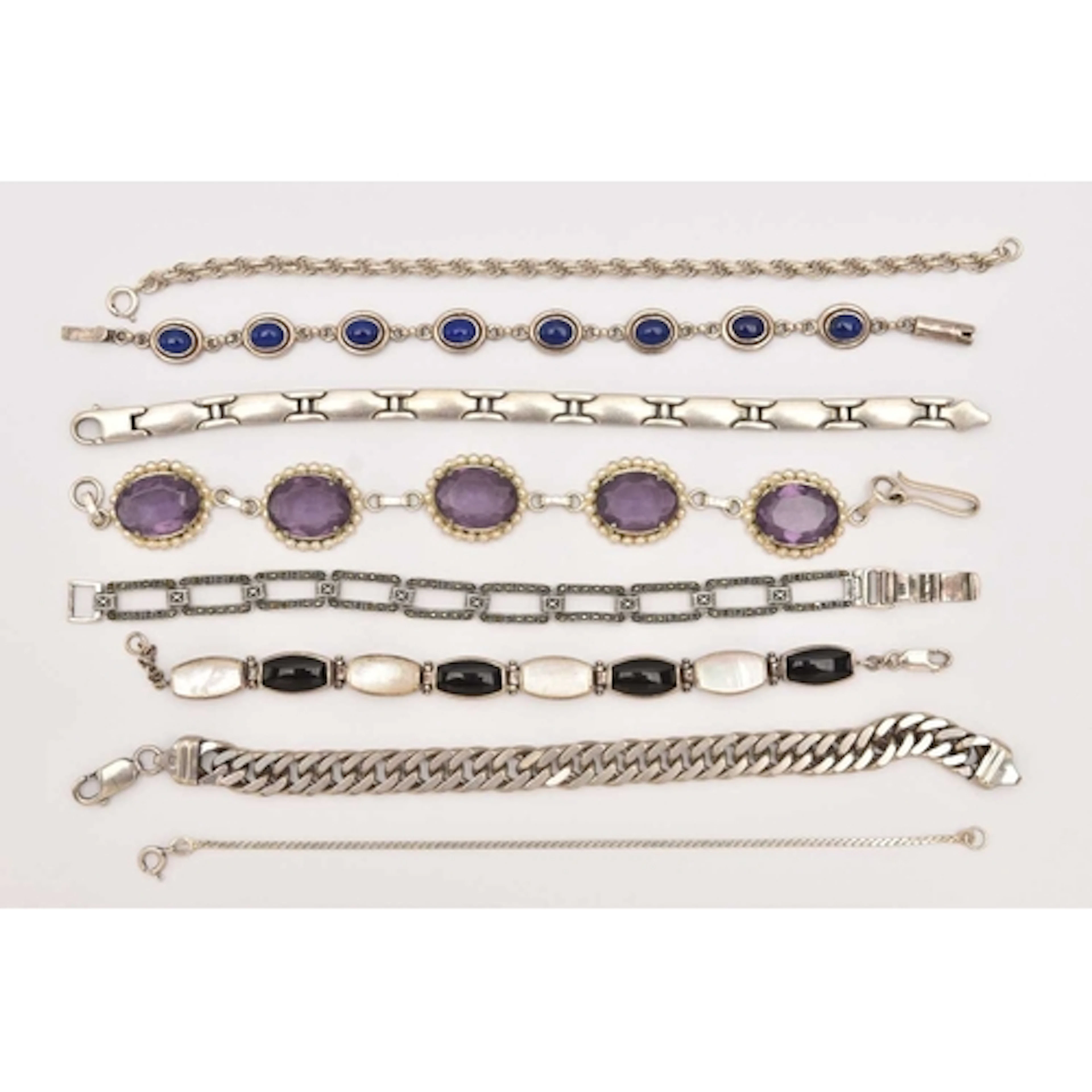 AN ASSORTMENT OF SILVER AND WHITE METAL BRACELETS, to includ...