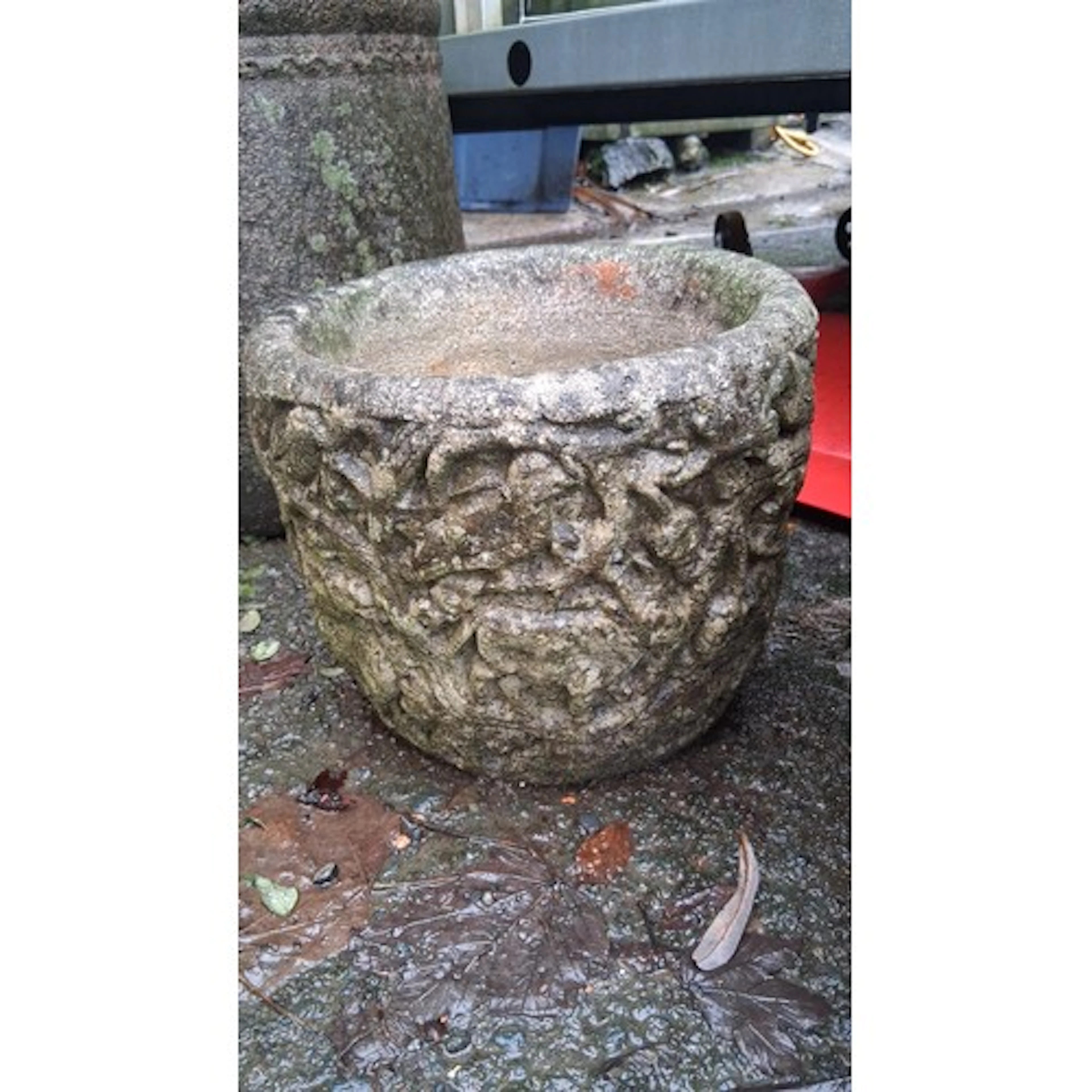 A cast stone garden planter of squat cylindrical form, the e...