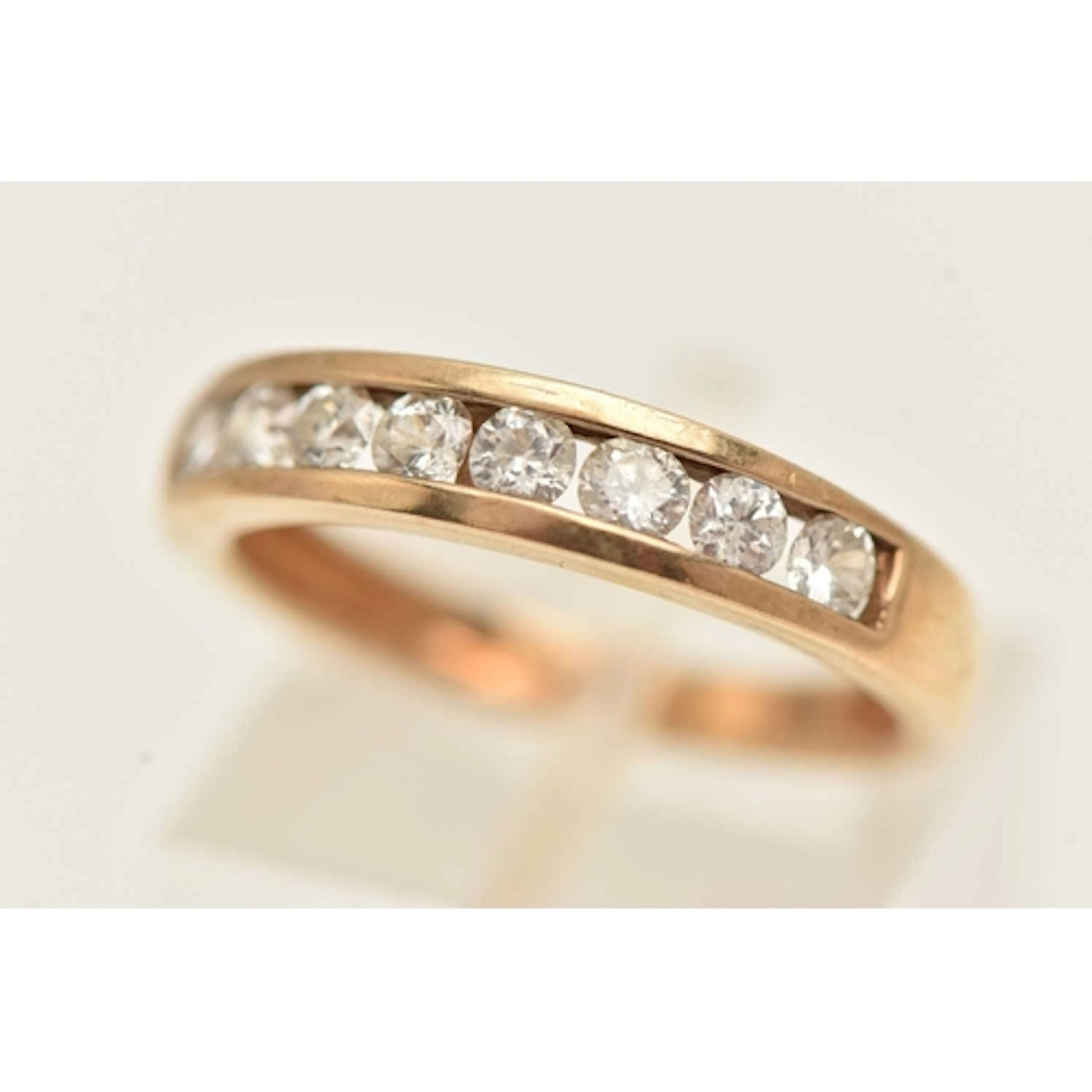 A 9CT GOLD GEM SET RING, yellow gold band ring channel set w...