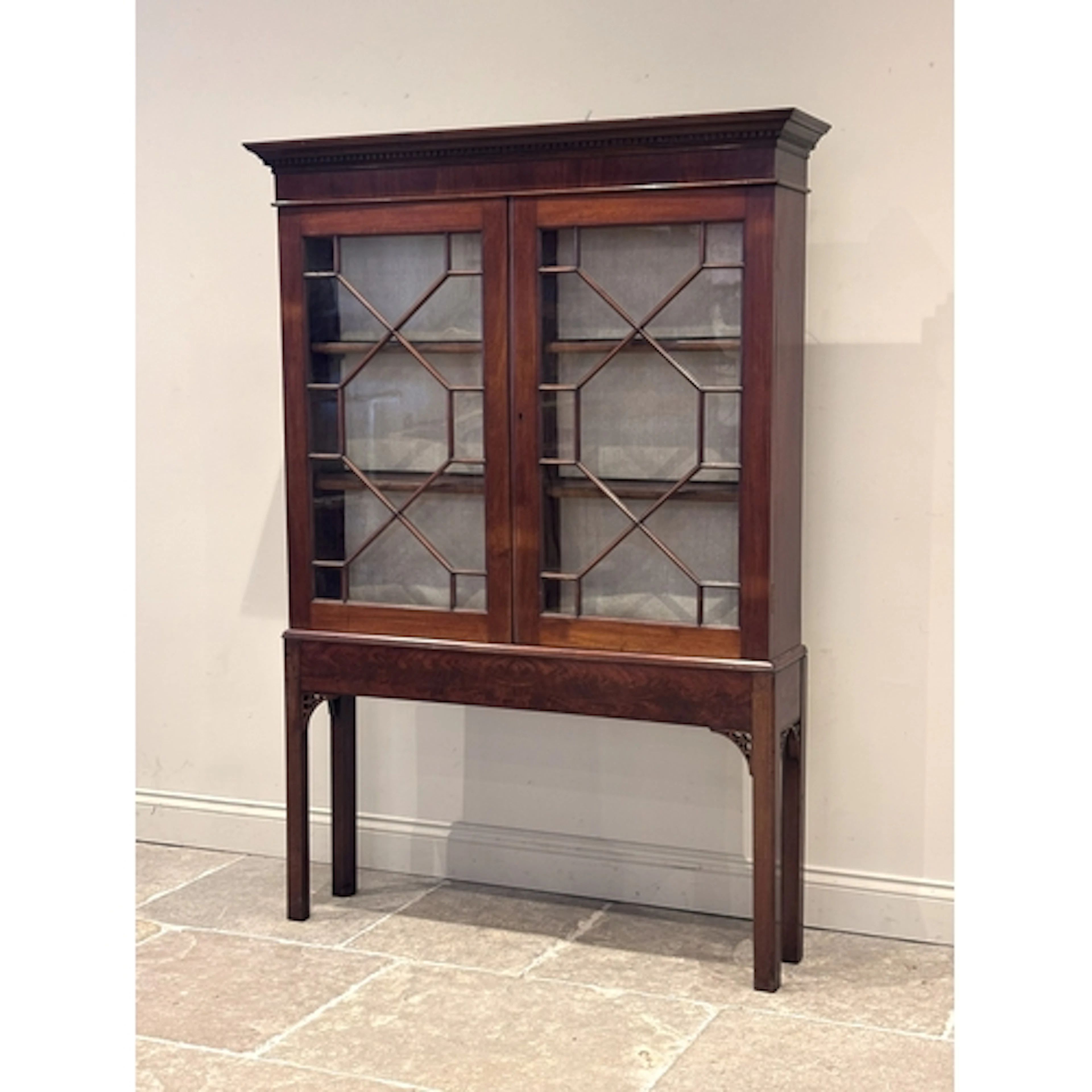 A George III mahogany cabinet on stand, in the manner of Tho...