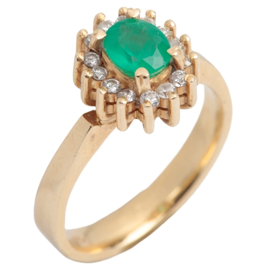 An emerald and diamond cluster ring, claw-set with an oval e...