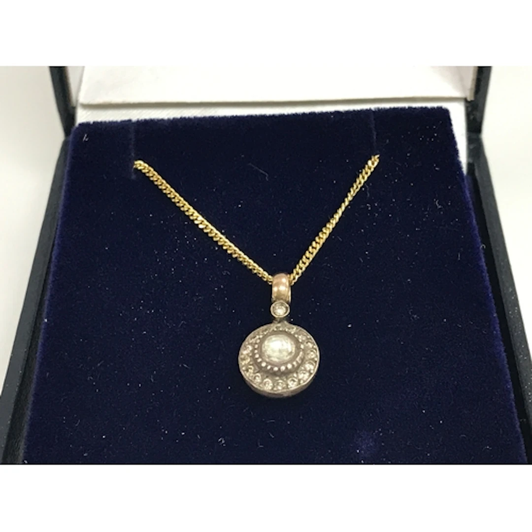 8ct (unmarked) silver topped diamond set pendant on a gold p...