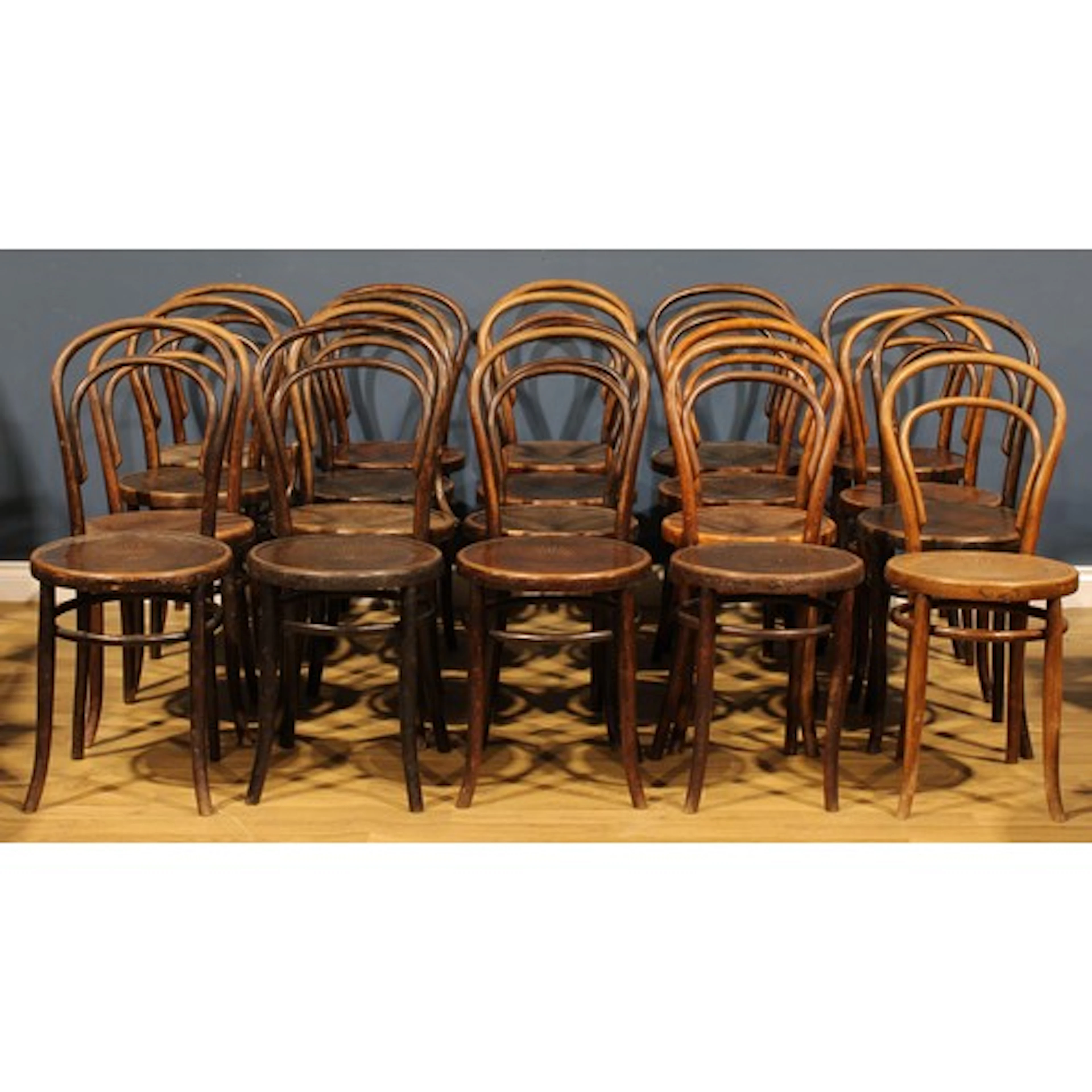 A harlequin suite of twenty bentwood bistro chairs, in the m...