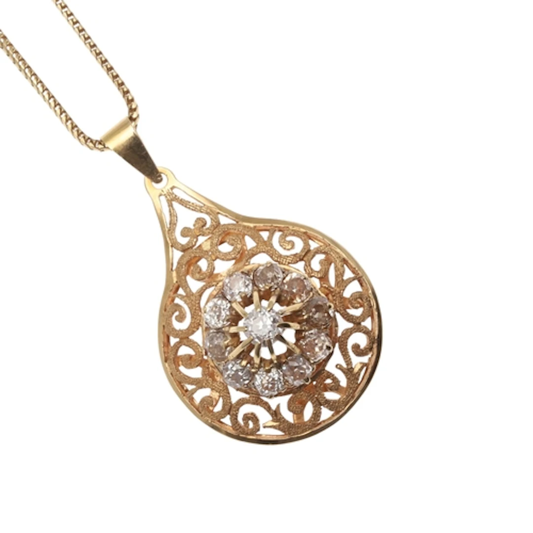 A DIAMOND AND 18CT GOLD PENDANT. the mount of openwork desig...