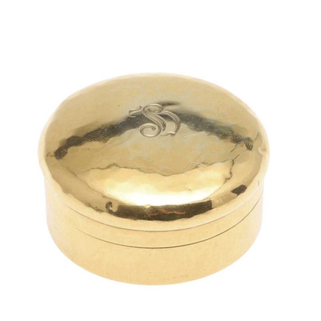 AN 18CT GOLD PILL BOX BY TIFFANY. circular, the cover engrav...