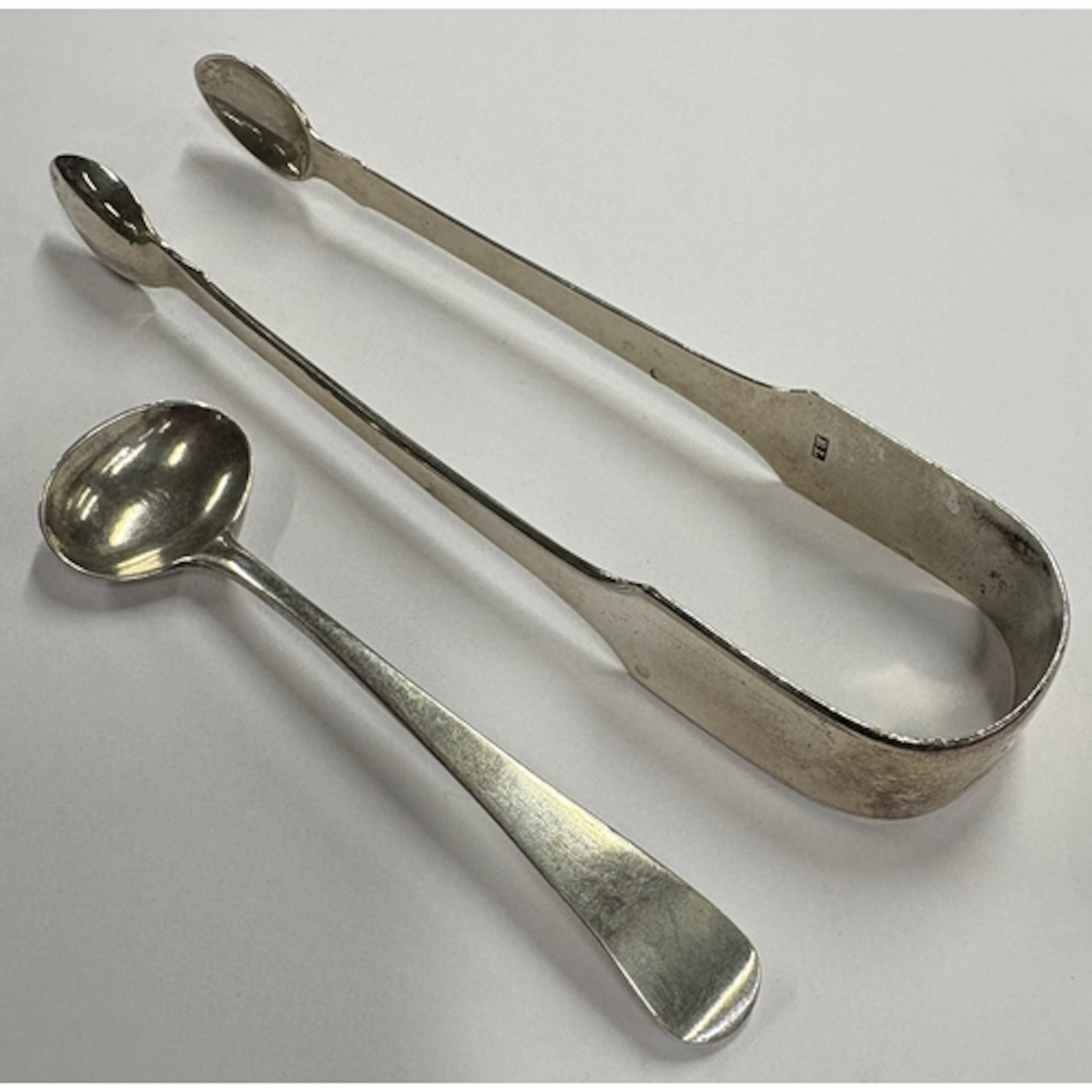 A pair of Georgian silver fiddle pattern tongs together with...