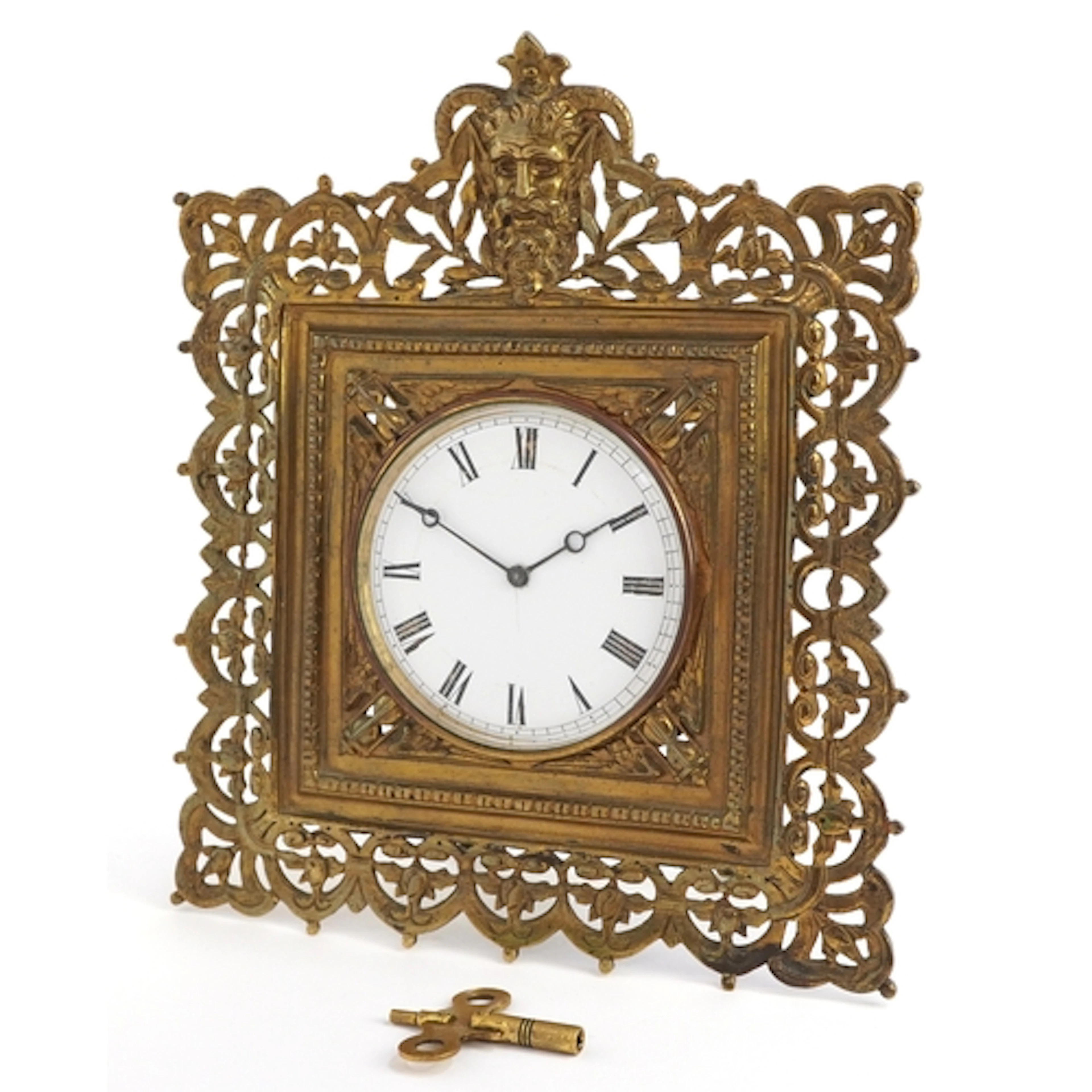 Antique brass strut clock embossed with masks and engraved w...