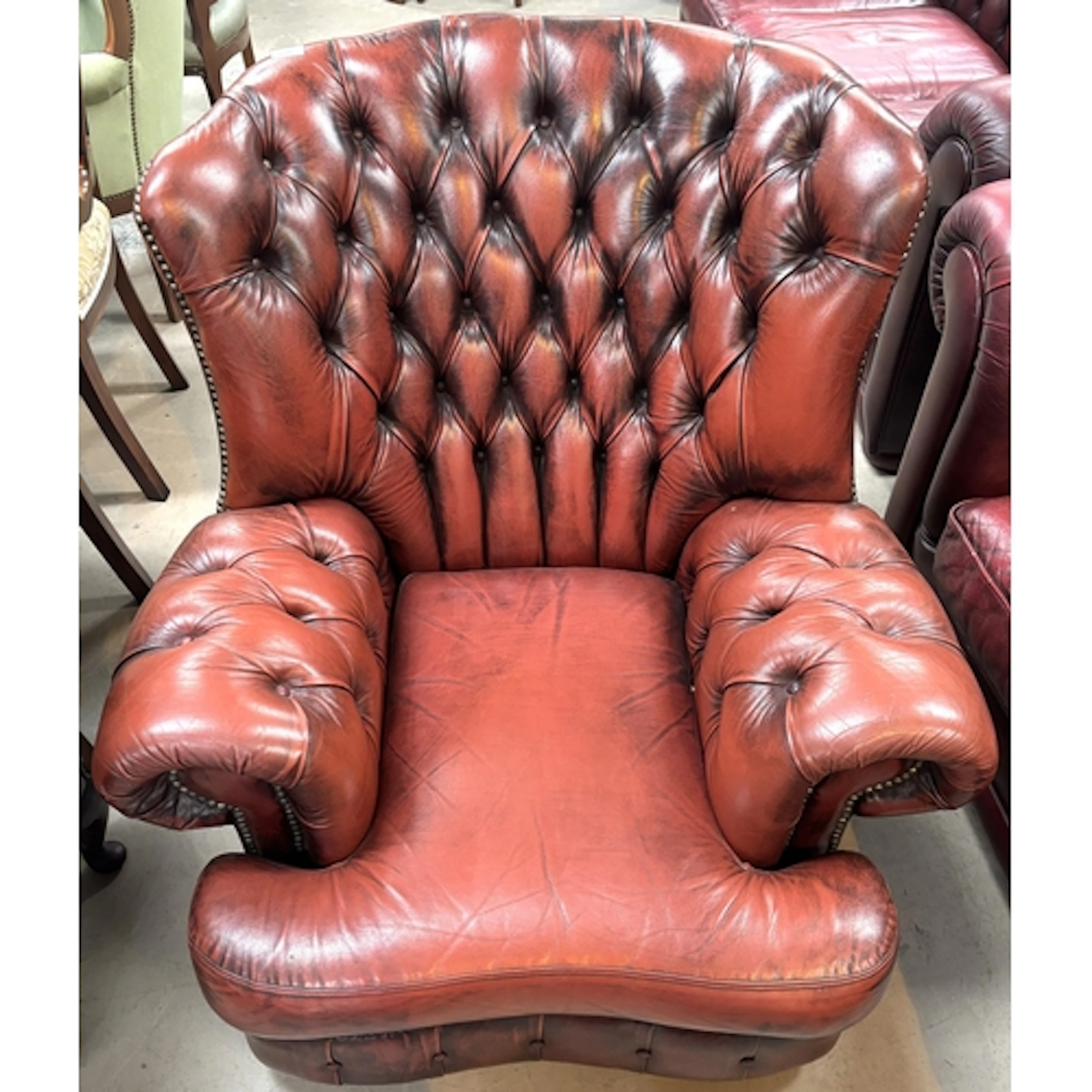 A deeply buttoned Chesterfield wing back armchair in "antiqu...