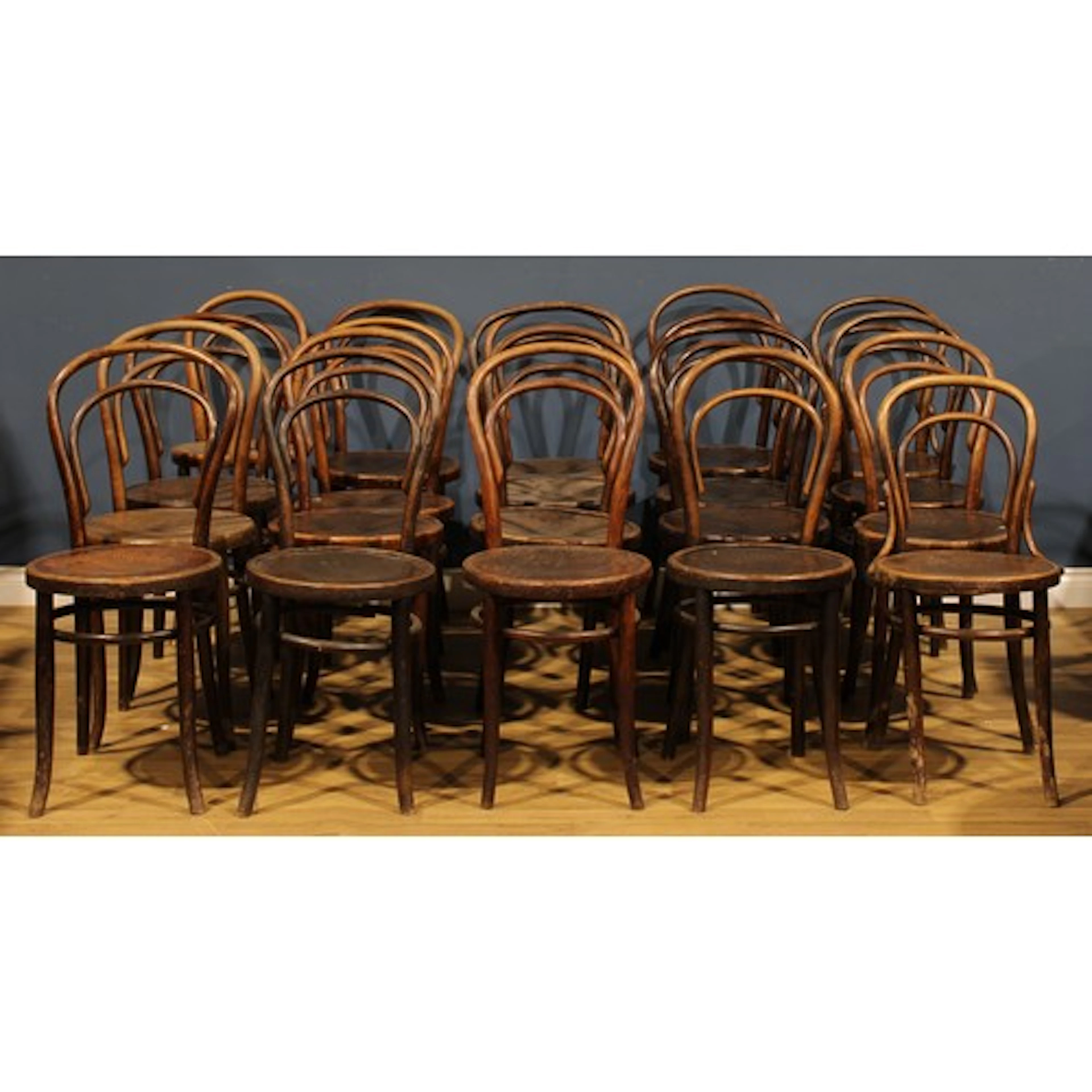 A harlequin suite of twenty bentwood bistro chairs, in the m...