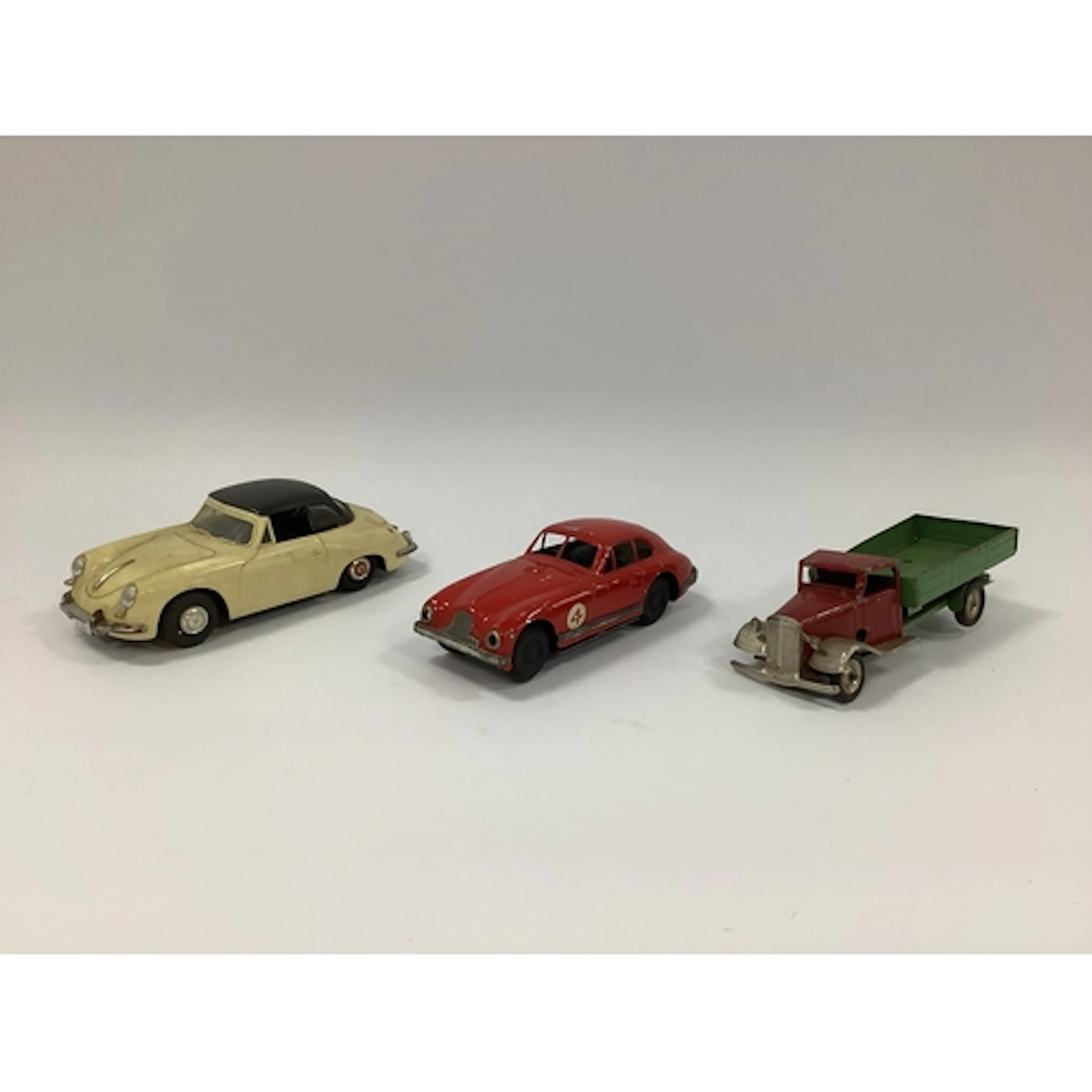 Three Mid XX century toy vehicles. A Scalex Aston Martin DB2...
