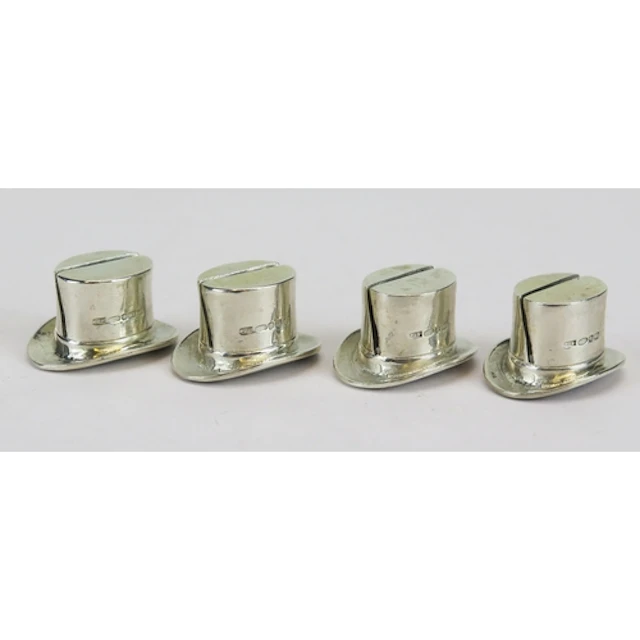 A set of four silver novelty menu holders in the form of top...