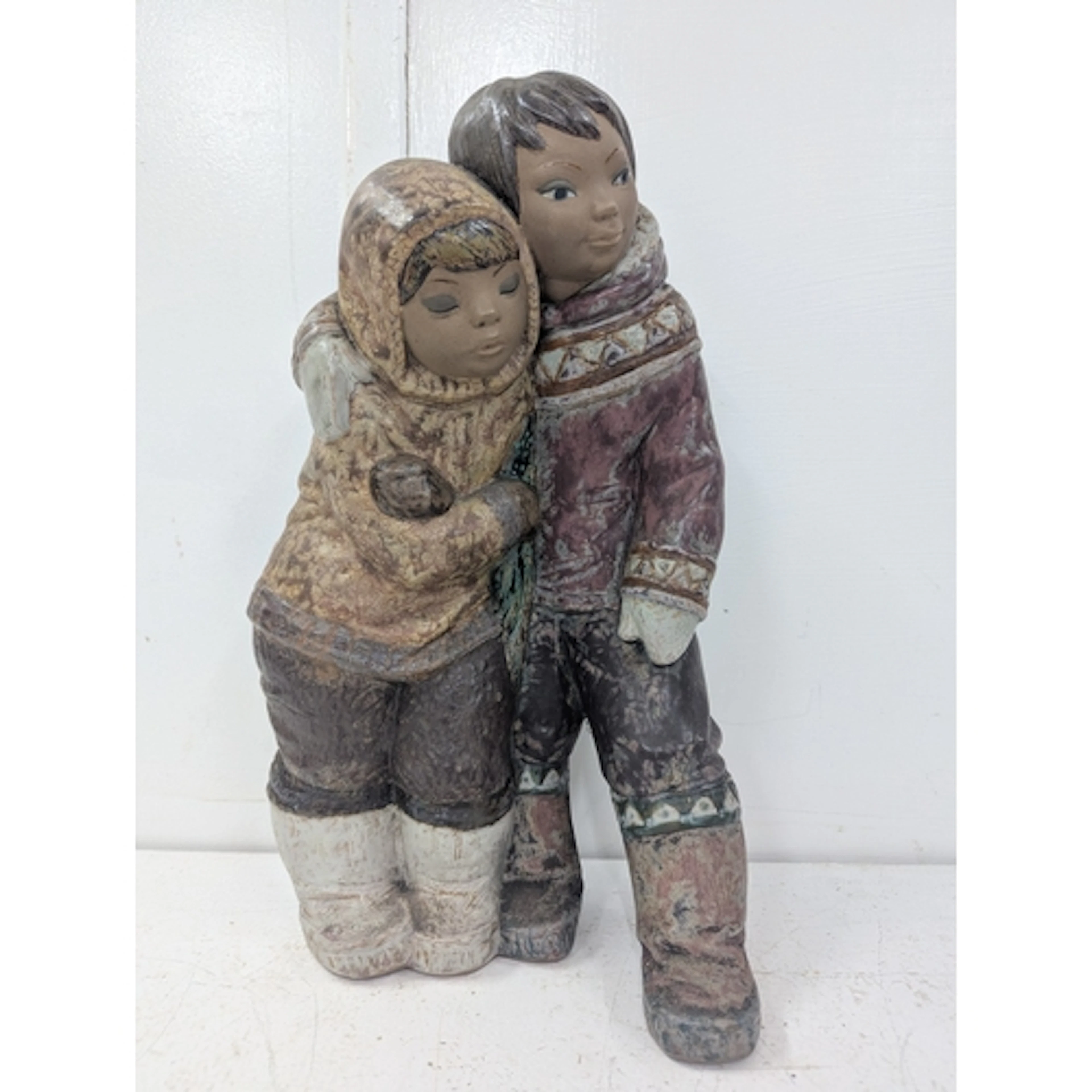 A large Lladro figure depicting an Eskimo boy and girl title...