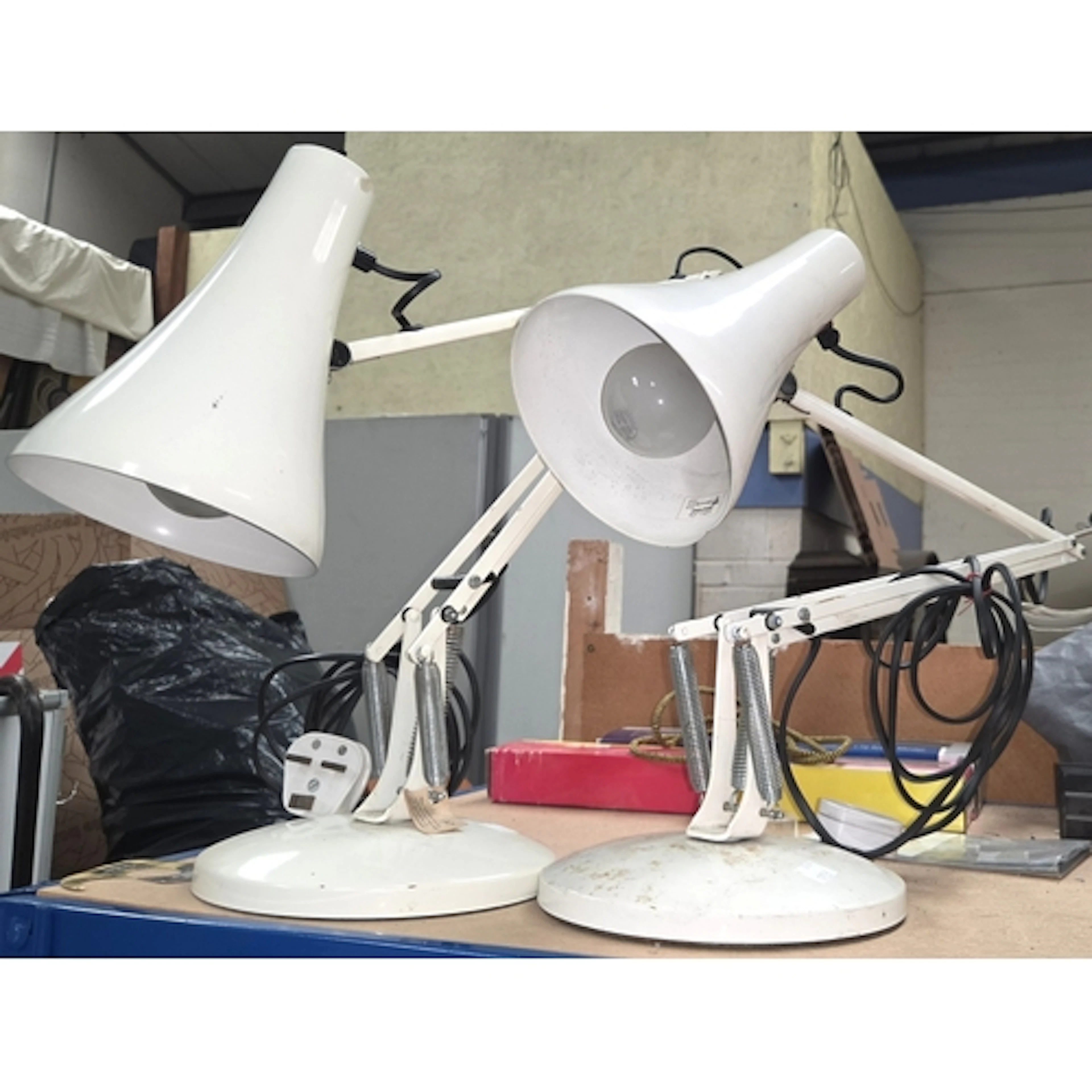 A pair of modern white angle poise table lamps.