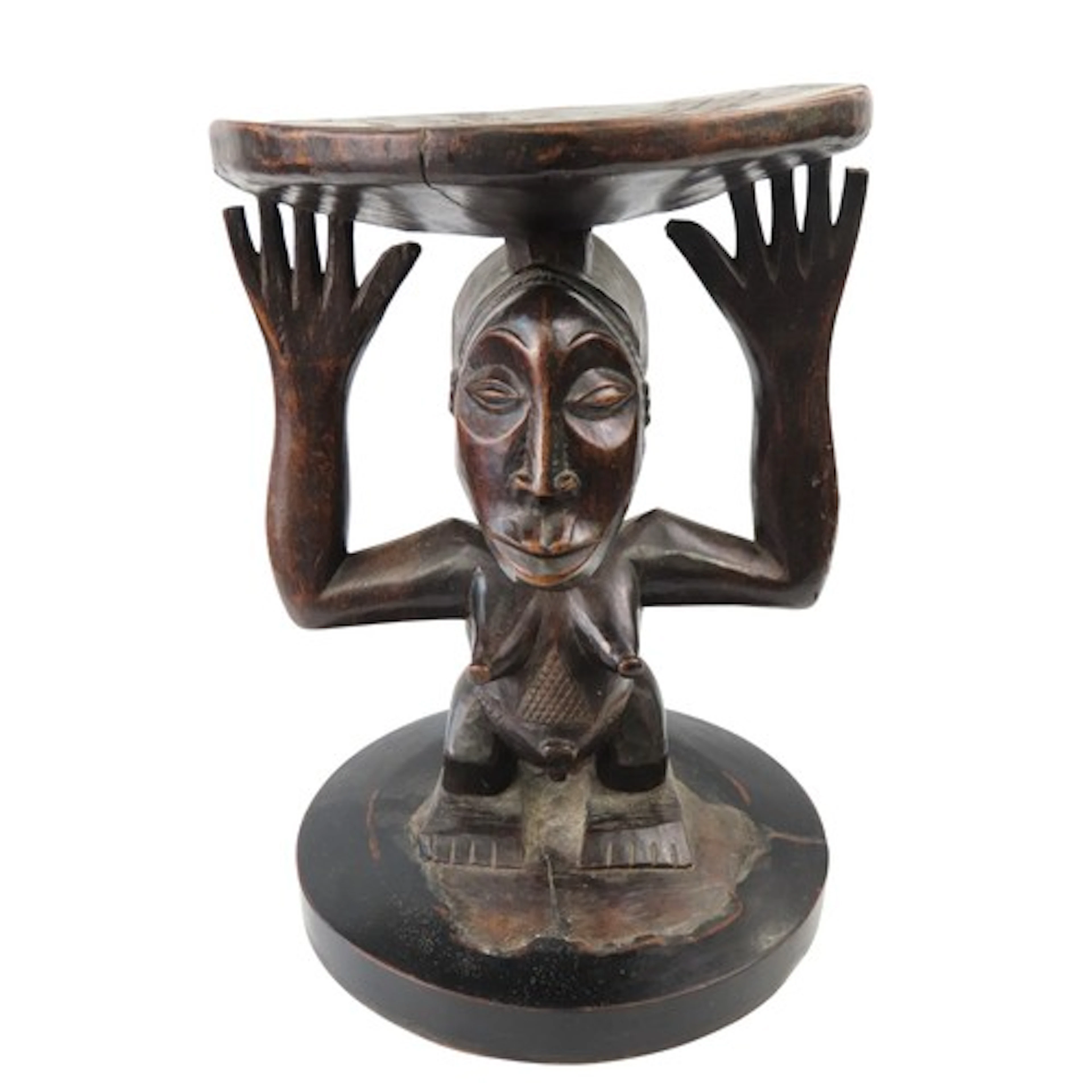 A LUBA CARVED WOODEN STOOL the circular dished top supported...