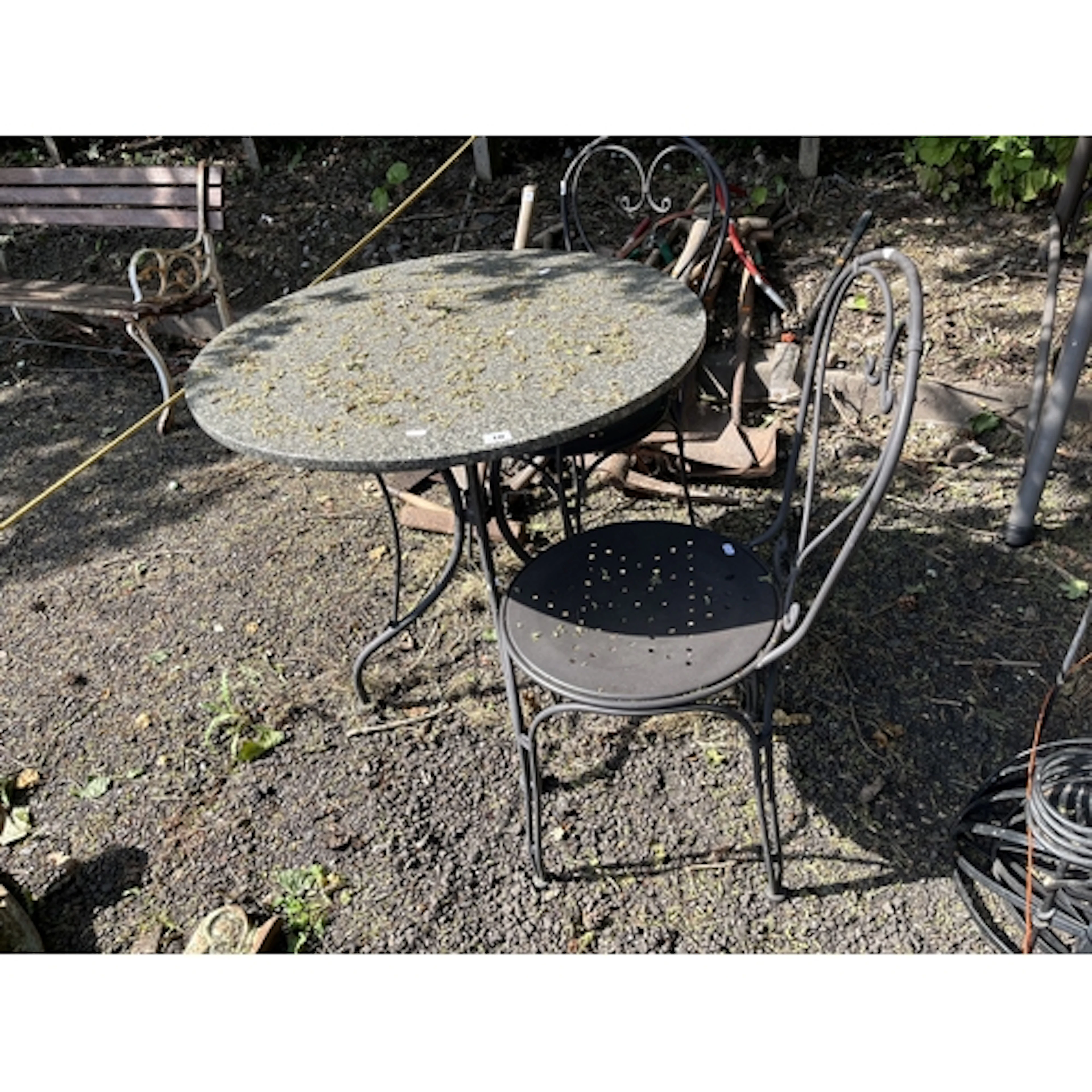 A MODERN WROUGHT IRON AND GRANITE GARDEN TABLE AND TWO CHAIR...