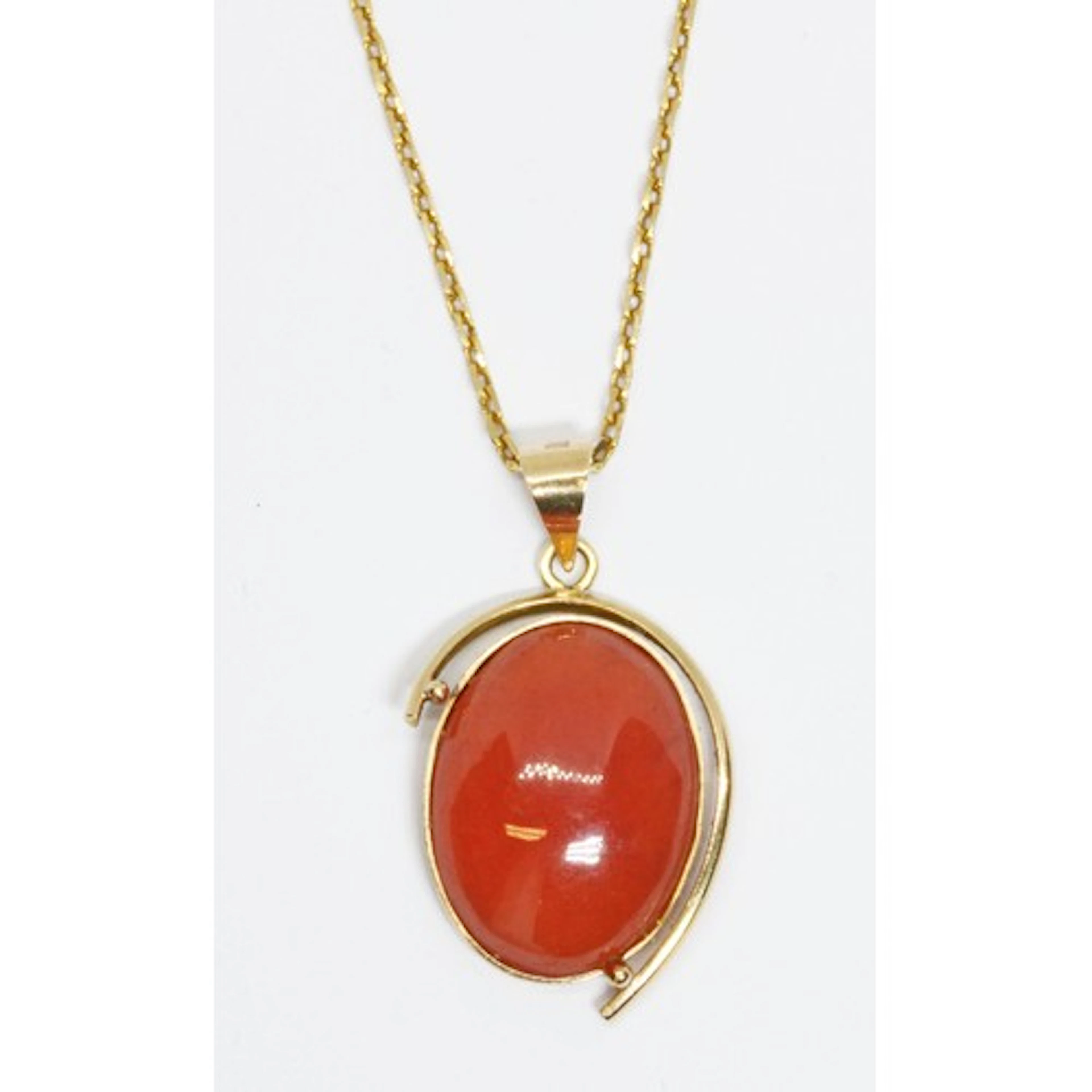 A rhodochrosite cabochon pendant necklace, the bezel set pin...