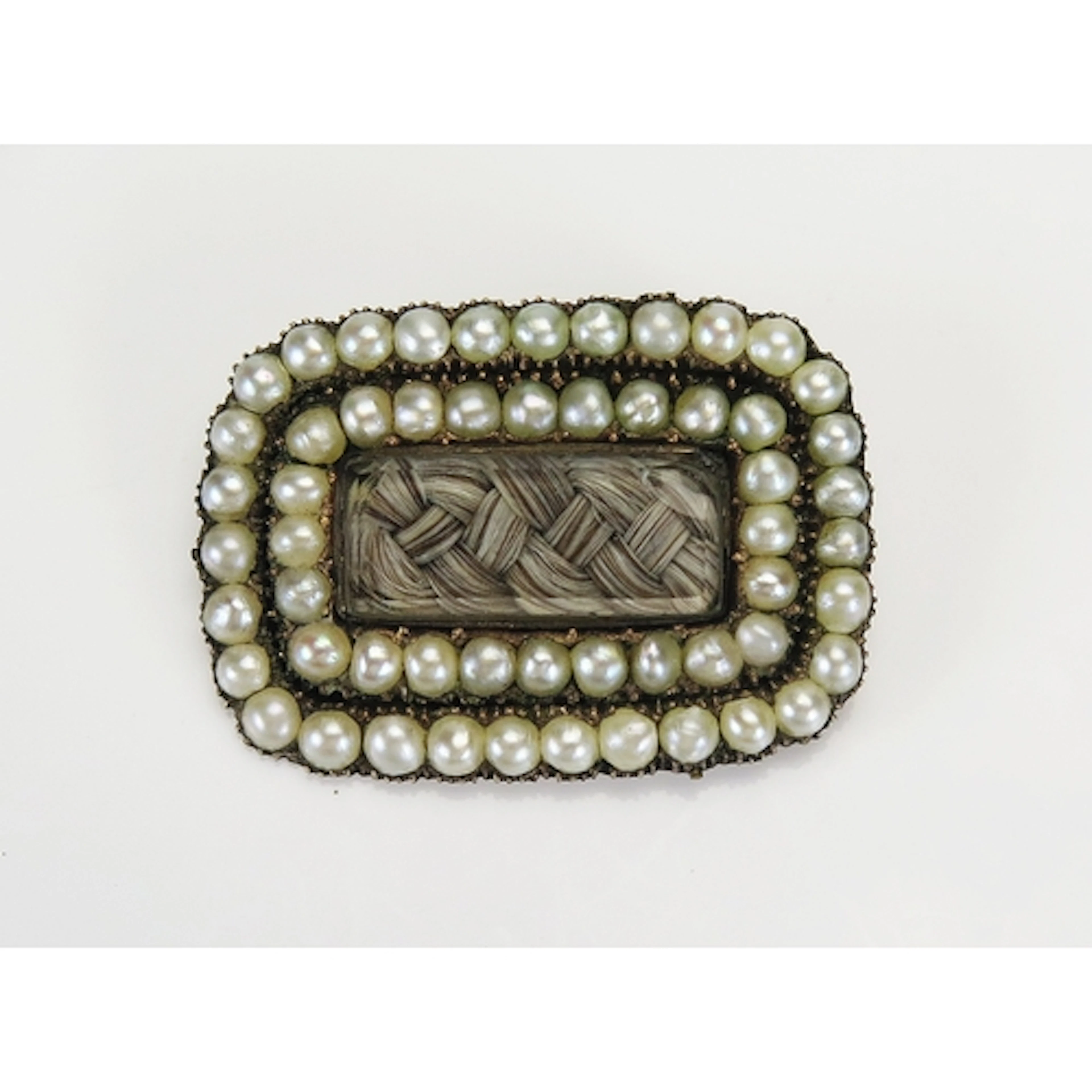 A Georgian split pearl memorial brooch with a central glazed...