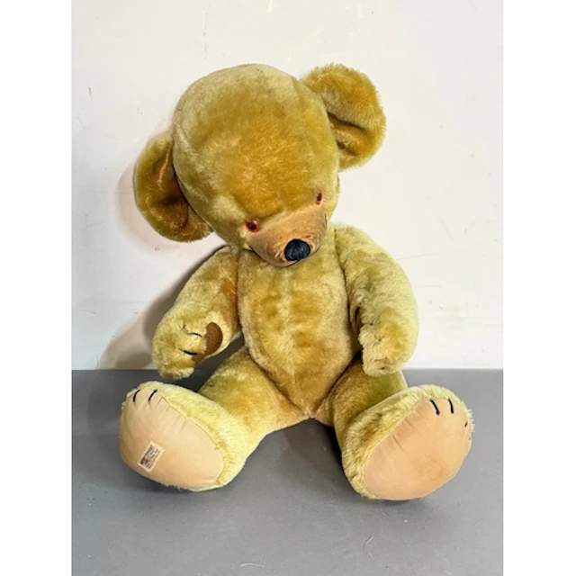 A vintage jointed Merrythought teddy bear with a label to fo...