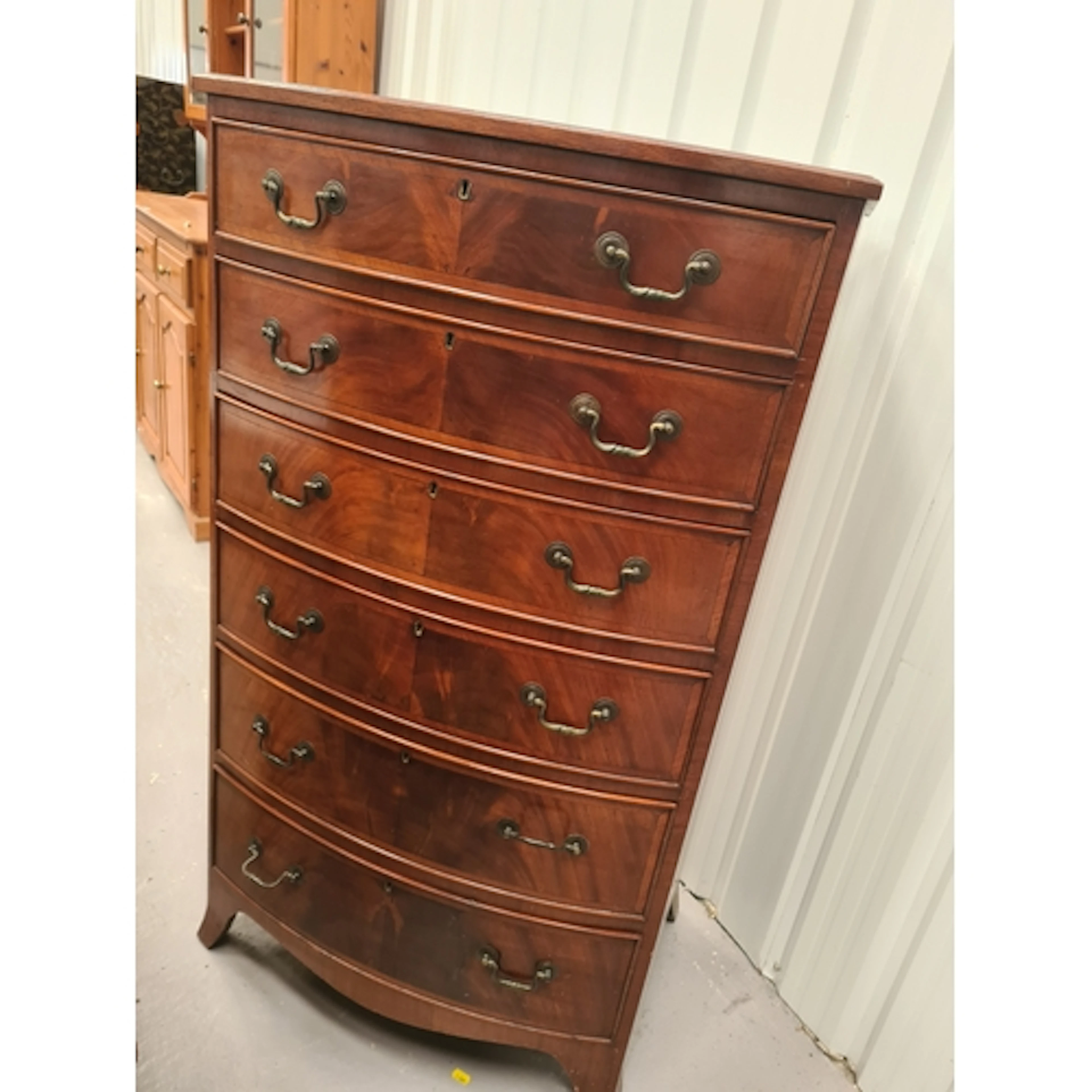 A Georgian style mahogany bow front Chest of six drawers wi...