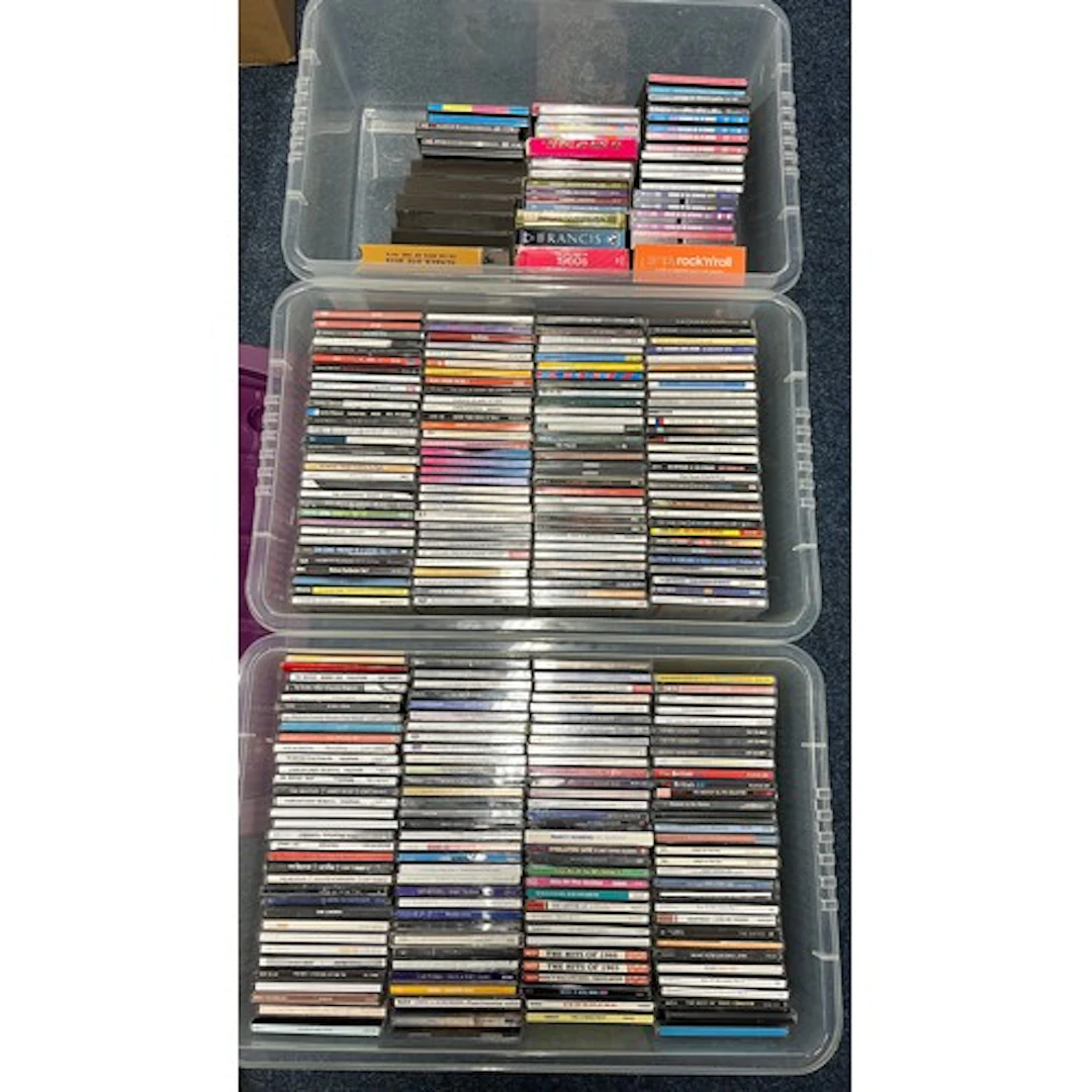 Three boxes containing mixed CDs.