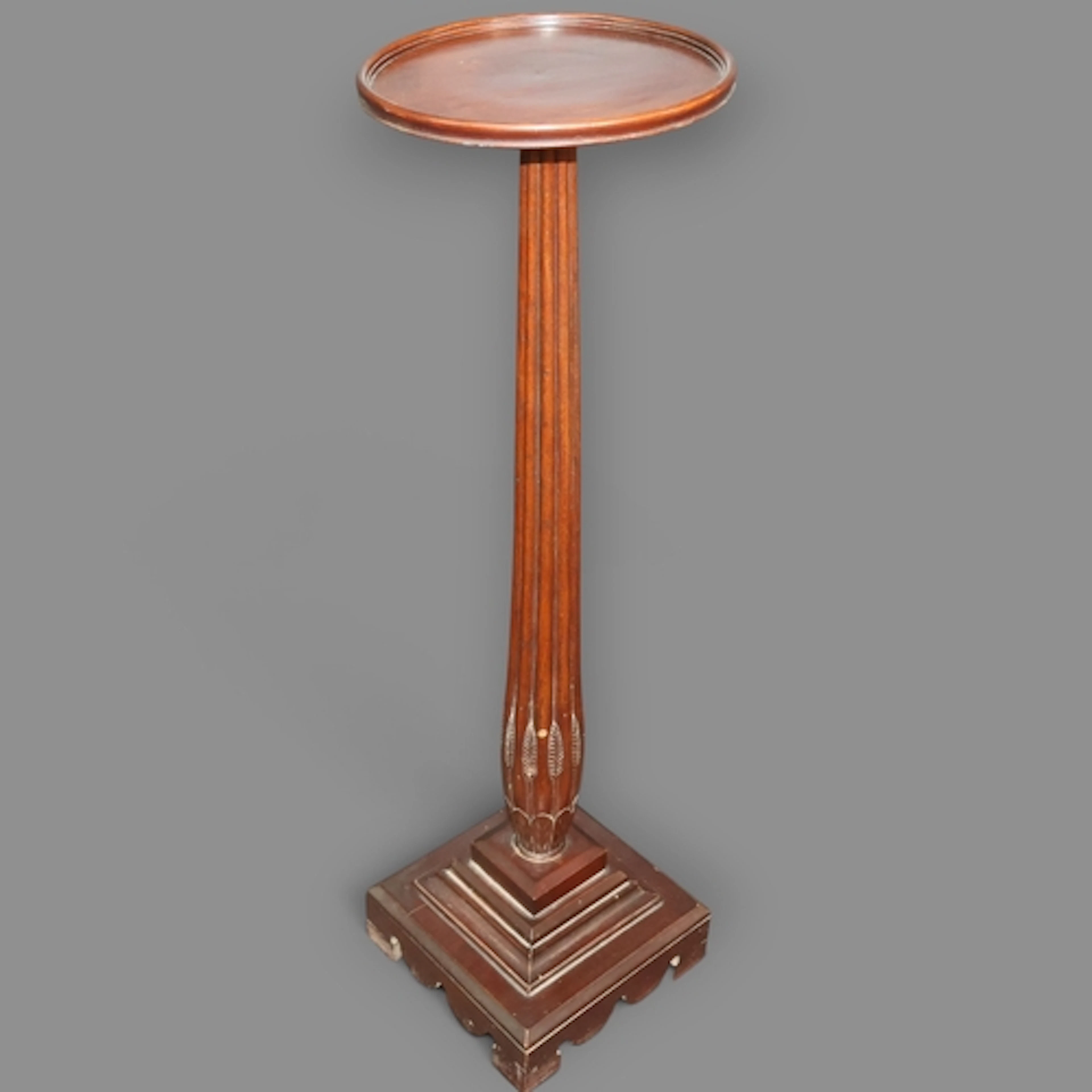 An antique mahogany Torchere, with fluted column and stepped...