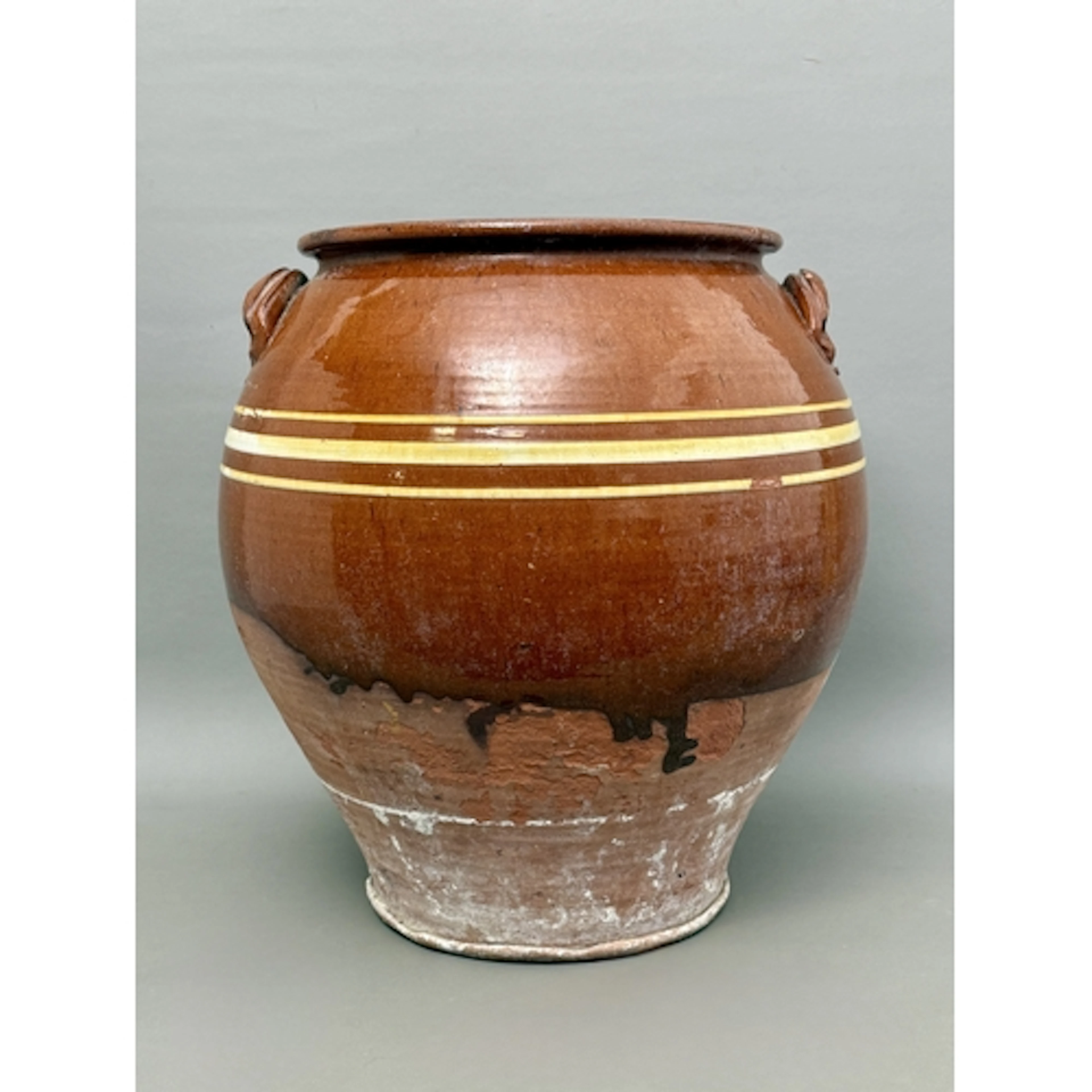 An antique terracotta planter or storage jar - part glazed w...
