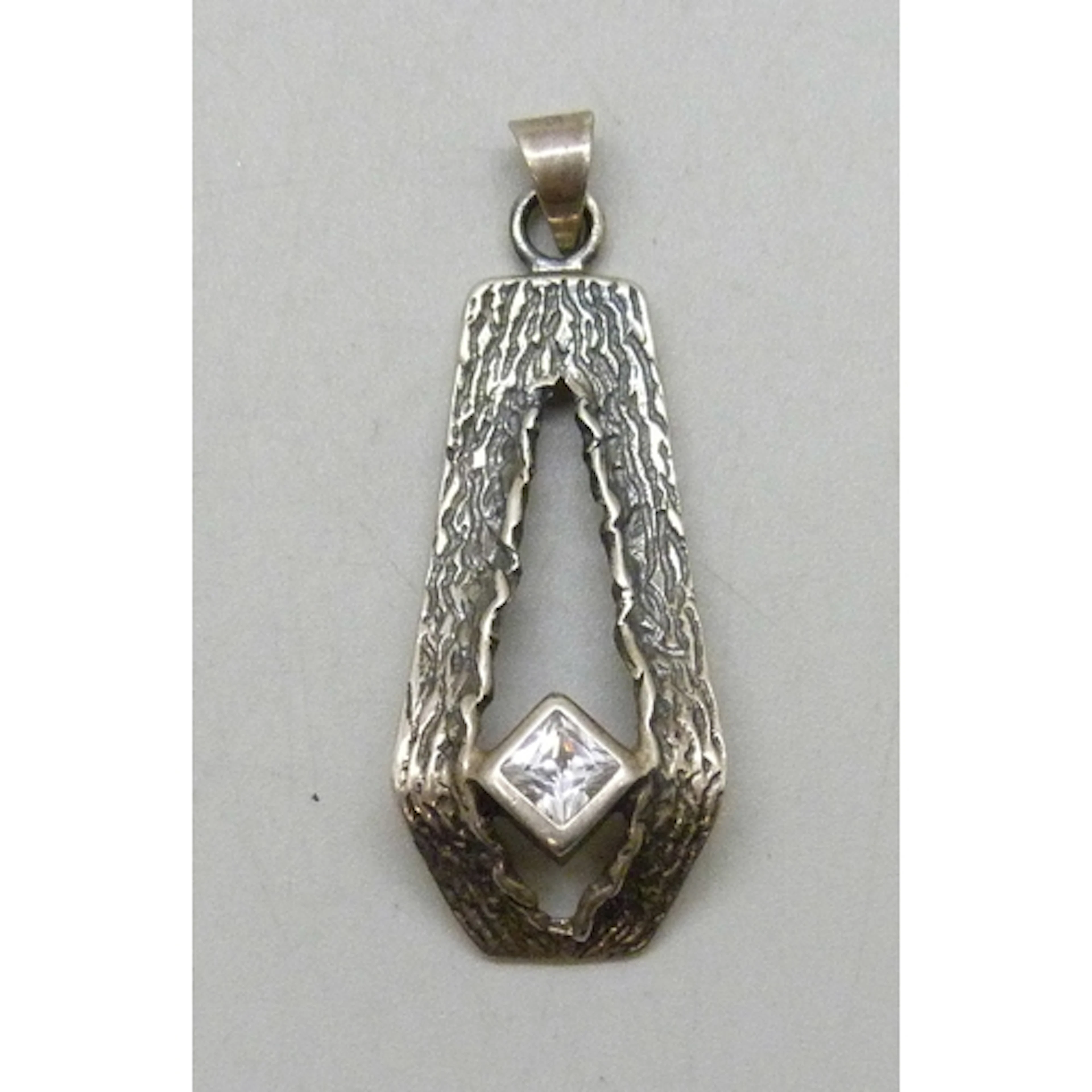A Modernist/Brutalist design silver pendant set with a white...