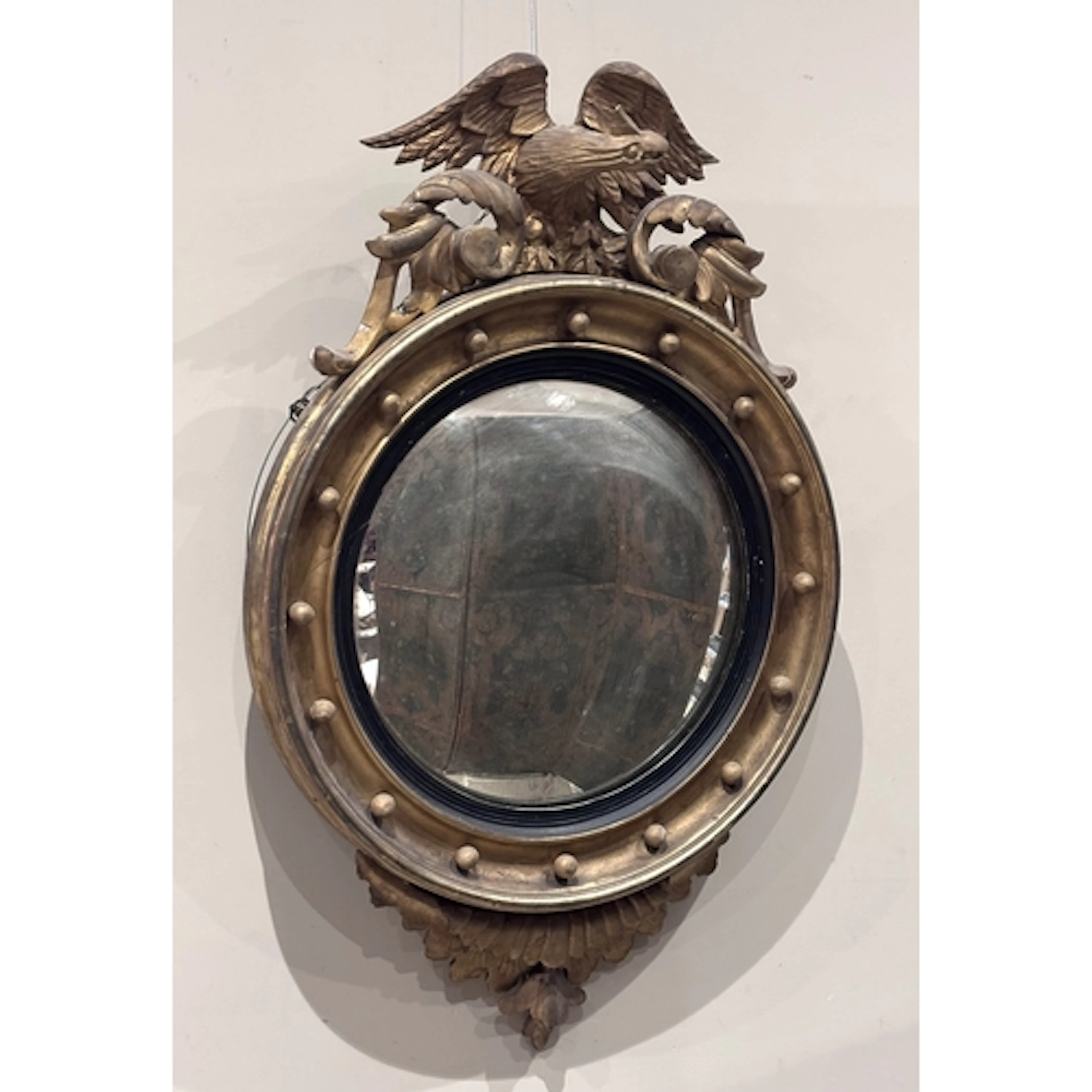 A Regency giltwood and gesso convex wall mirror, the circula...