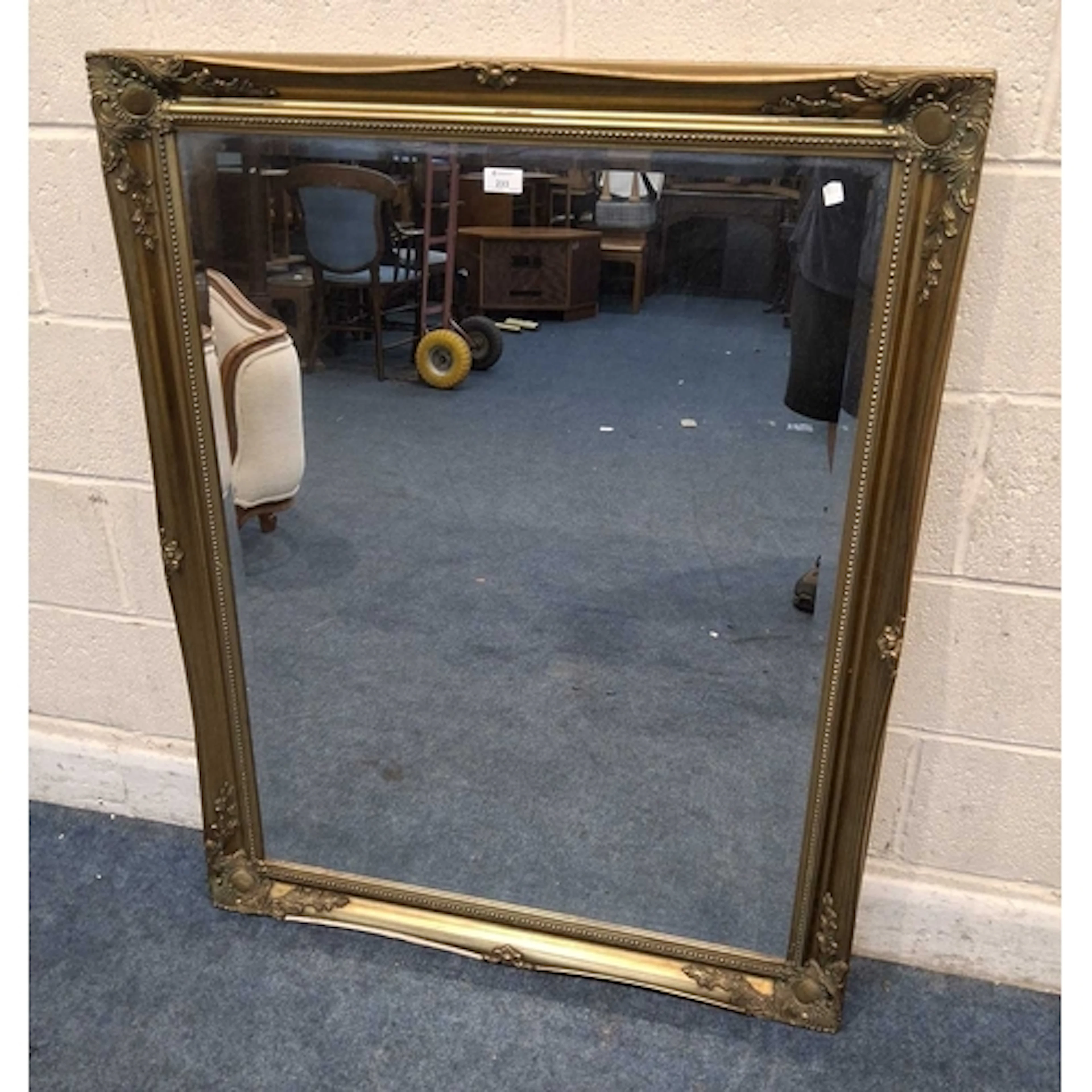 A GILT WOOD RECTANGULAR BEVELLED EDGE WALL MIRROR, with scro...