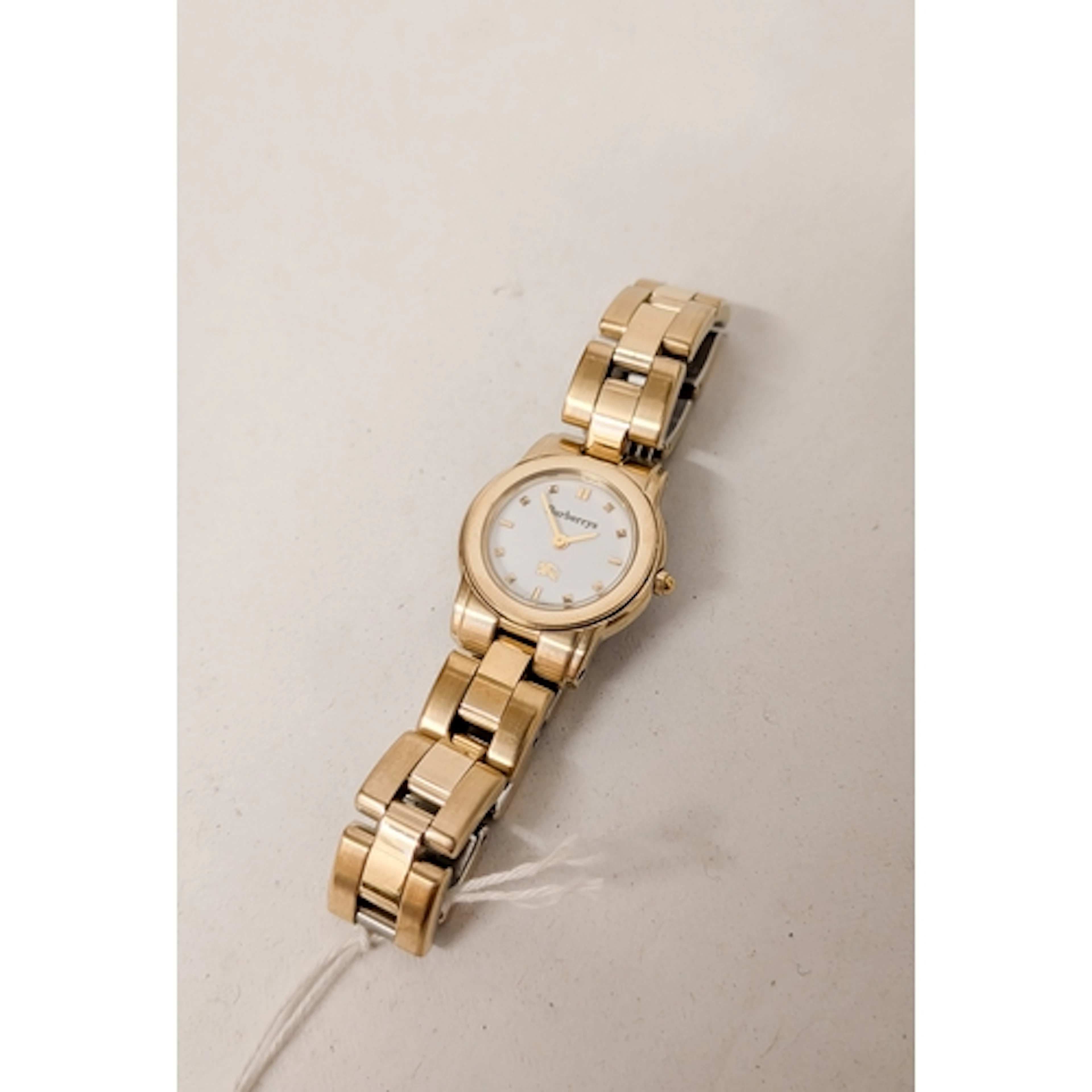 A modern ladies gilt Burberrys quartz wristwatch on a gilt s...