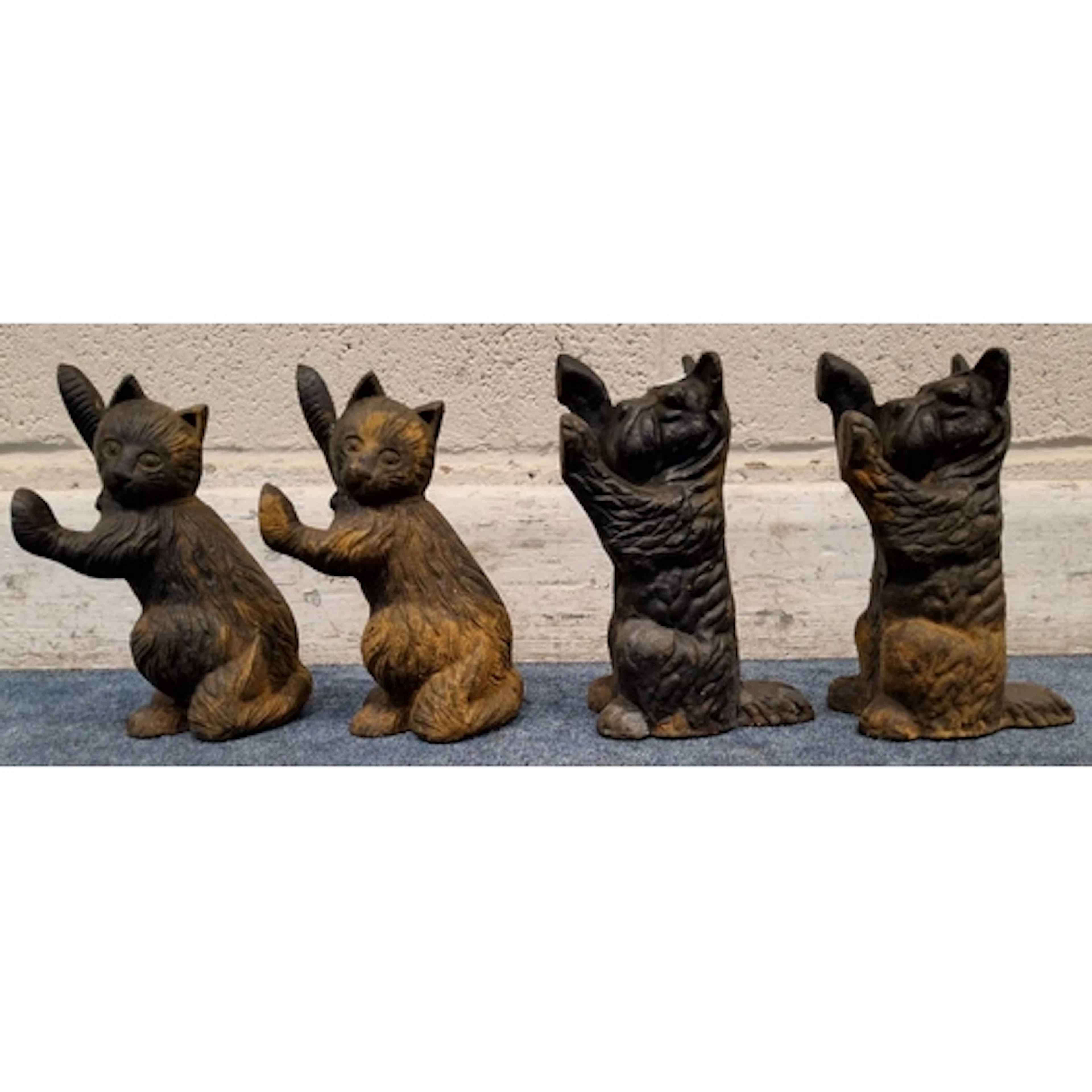 A PAIR OF CAST IRON CATS AND DOGS FIGURES, all holding their...