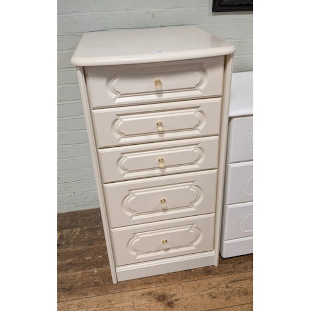 A matching cream tallboy chest of five long drawers with bra...