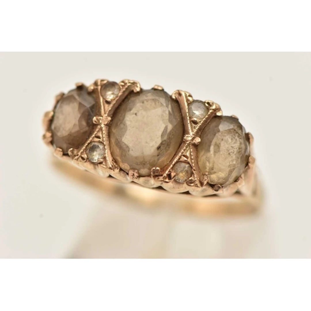 A YELLOW METAL SMOKY QUARTZ SET RING, set with three oval cu...