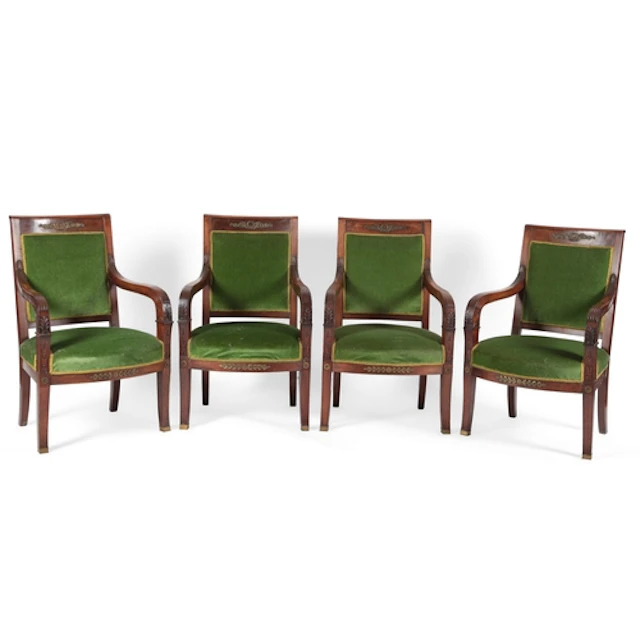 A set of four French Empire walnut fauteuils, each top rail ...