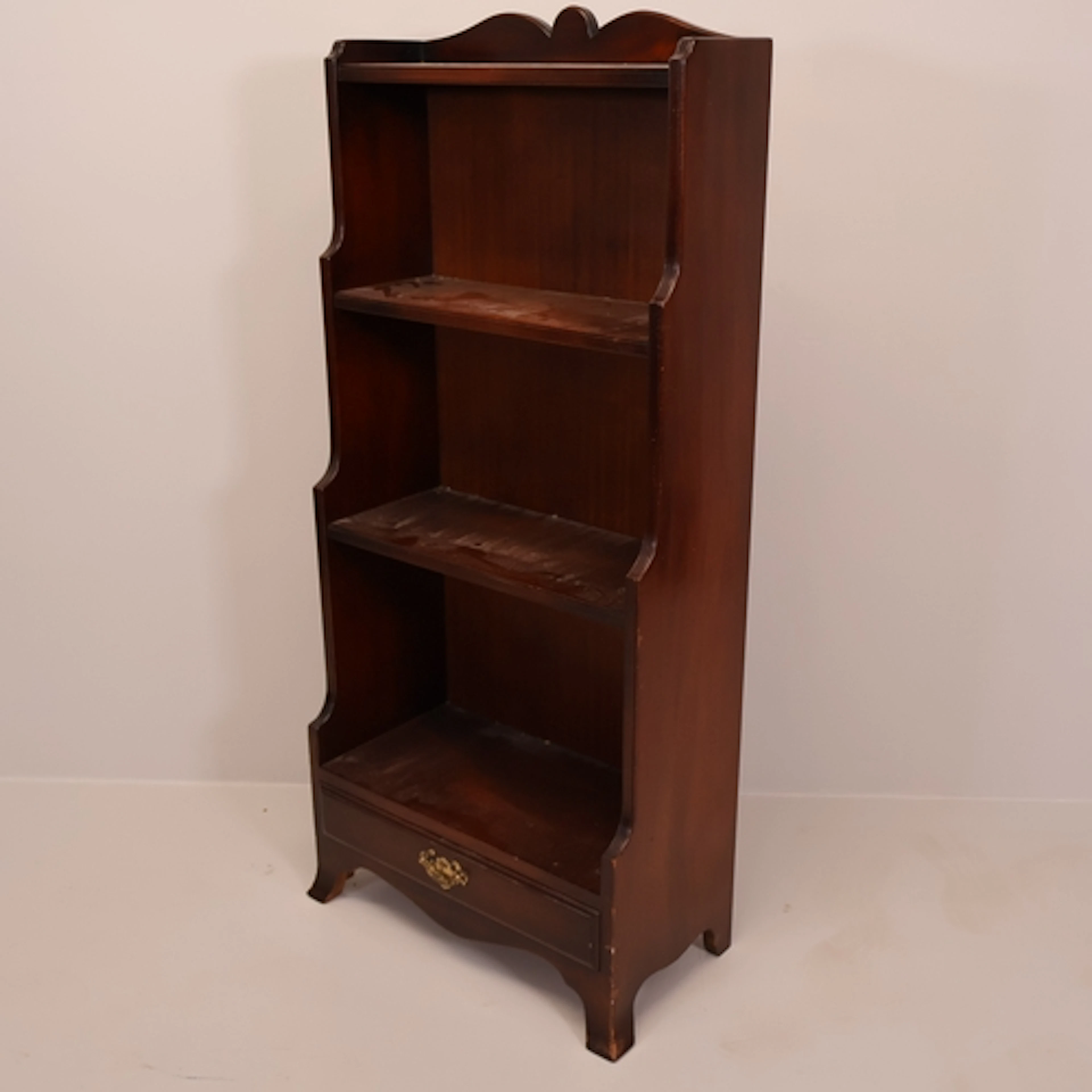 A modern mahogany waterfall open bookcase, with single drawe...