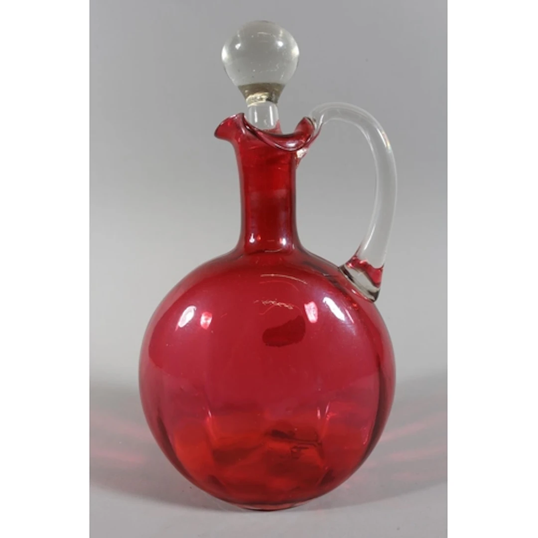 Cranberry glass water jug with teardrop stopper, 24cm high.