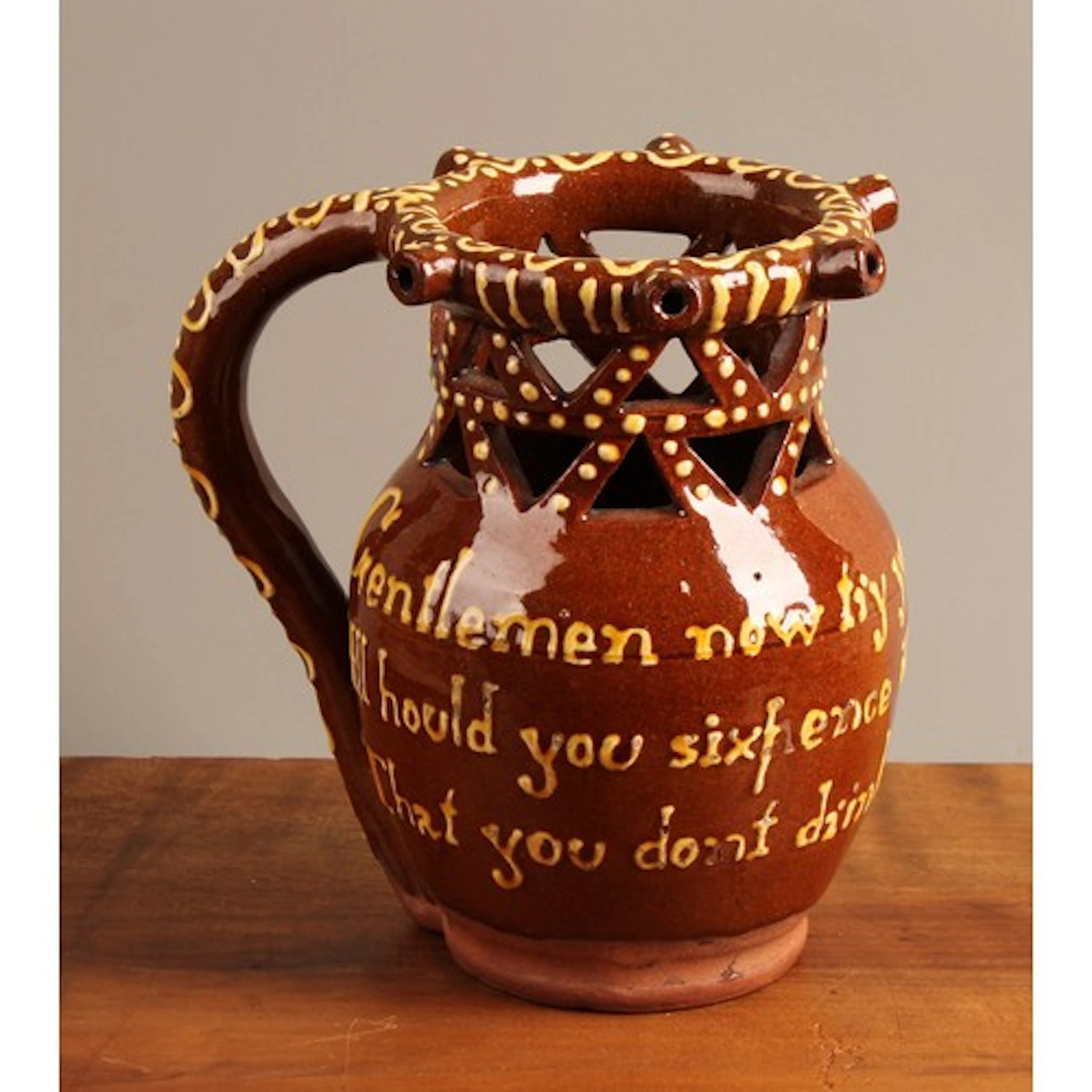 A 19th century Halifax slipware puzzle jug, the rim moulded ...