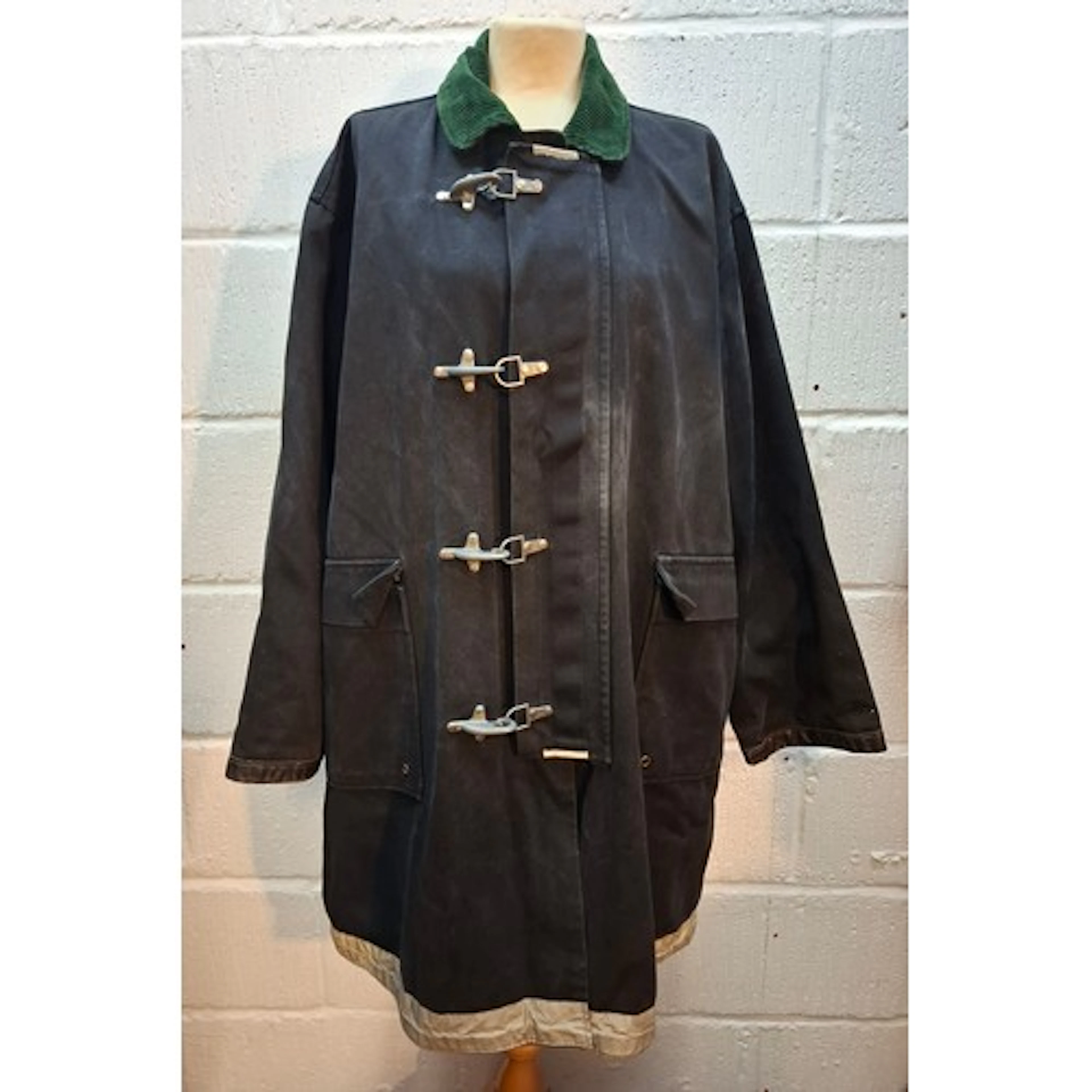A vintage Korean fireman's navy canvas jacket having a green...