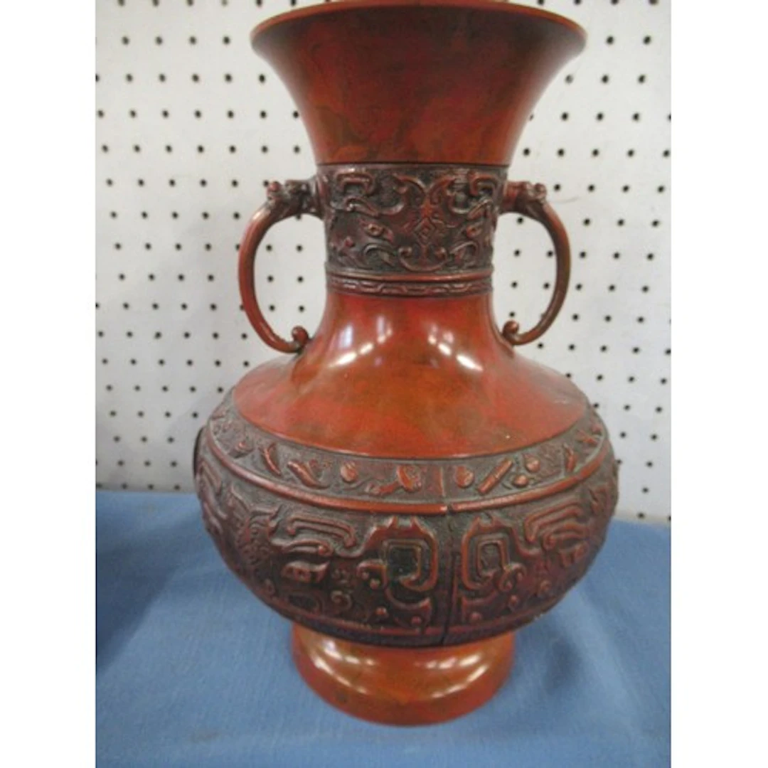 An oriental metal vase, decorated with a band of moulded fig...